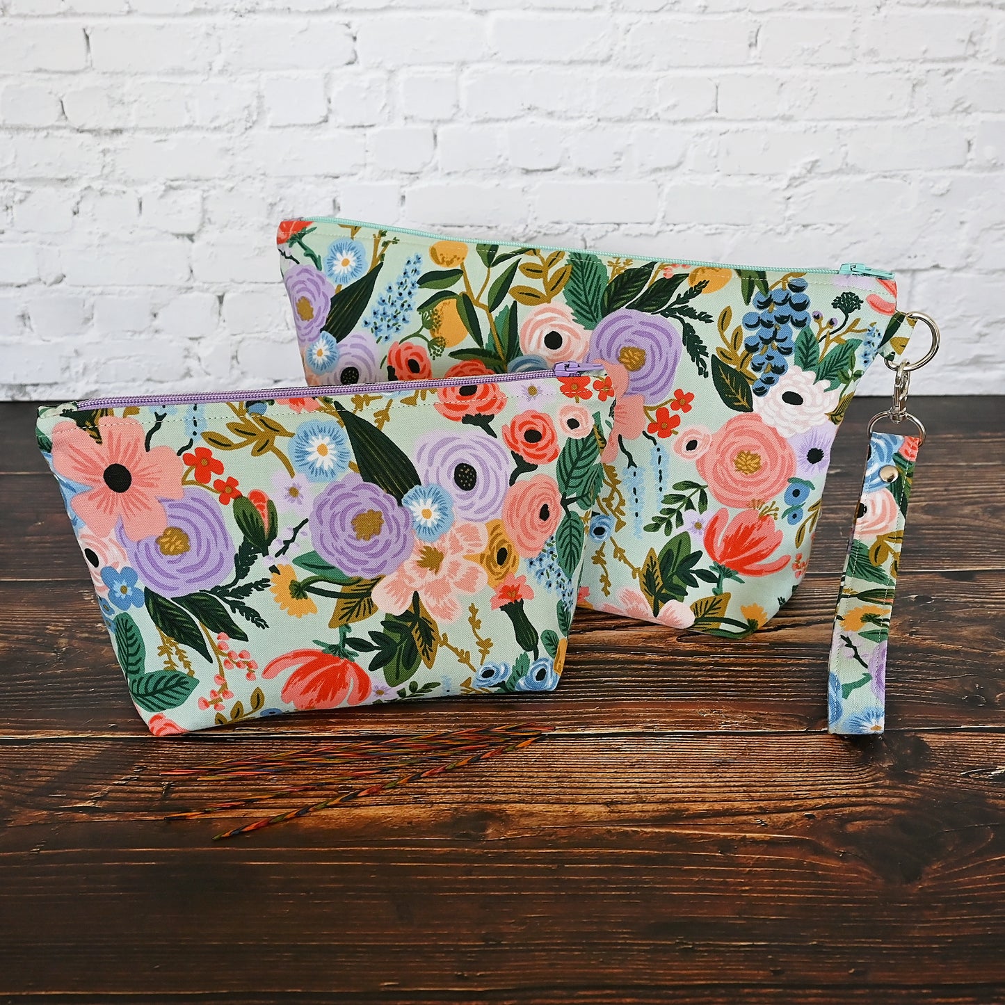 Aqua floral pouch with zipper closure and a removable wrist strap. Made from Rifle Paper Co's newest garden party collection and lined in a pale pink spotty fabric. Made in Canada by Yellow Petal Handmade.