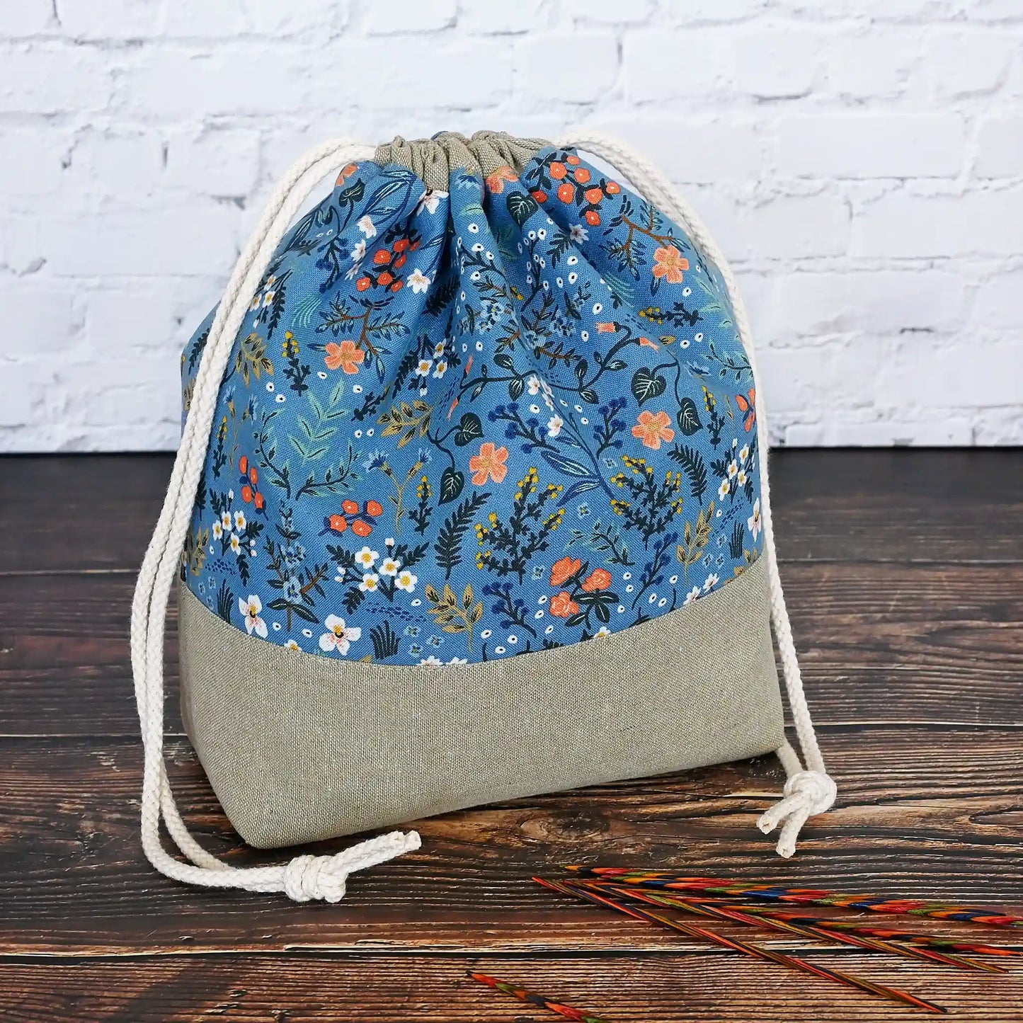 Pretty blue floral drawstring project bag paired with a pea green linen on the bottom.  This bag has interior slip pockets and is lined in a pretty cream floral cotton.  Made in Nova Scotia, Canada by Yellow Petal Handmade.