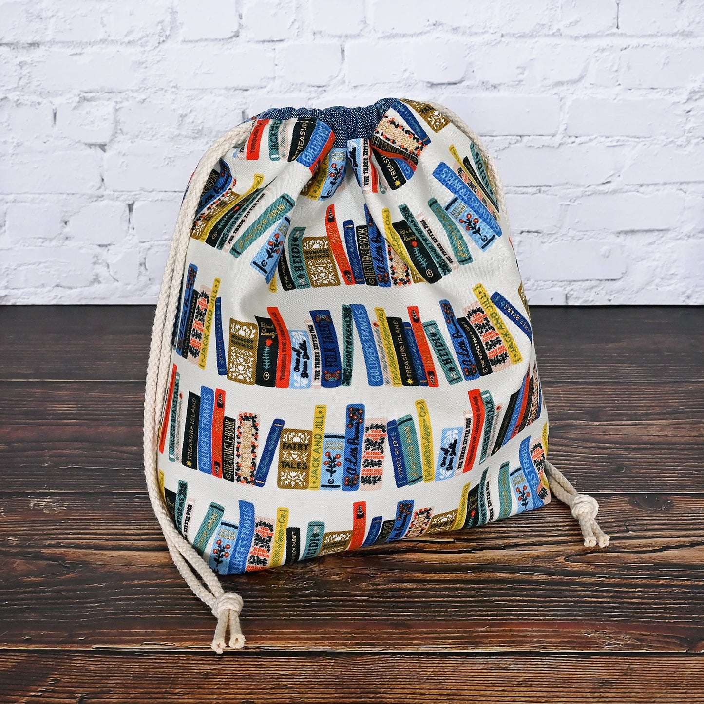 Book Club drawstring project bag from Rifle Paper's Curio collection. Lined in a pretty blue and white striped cotton. Made in Canada by Yellow Petal Handmade.