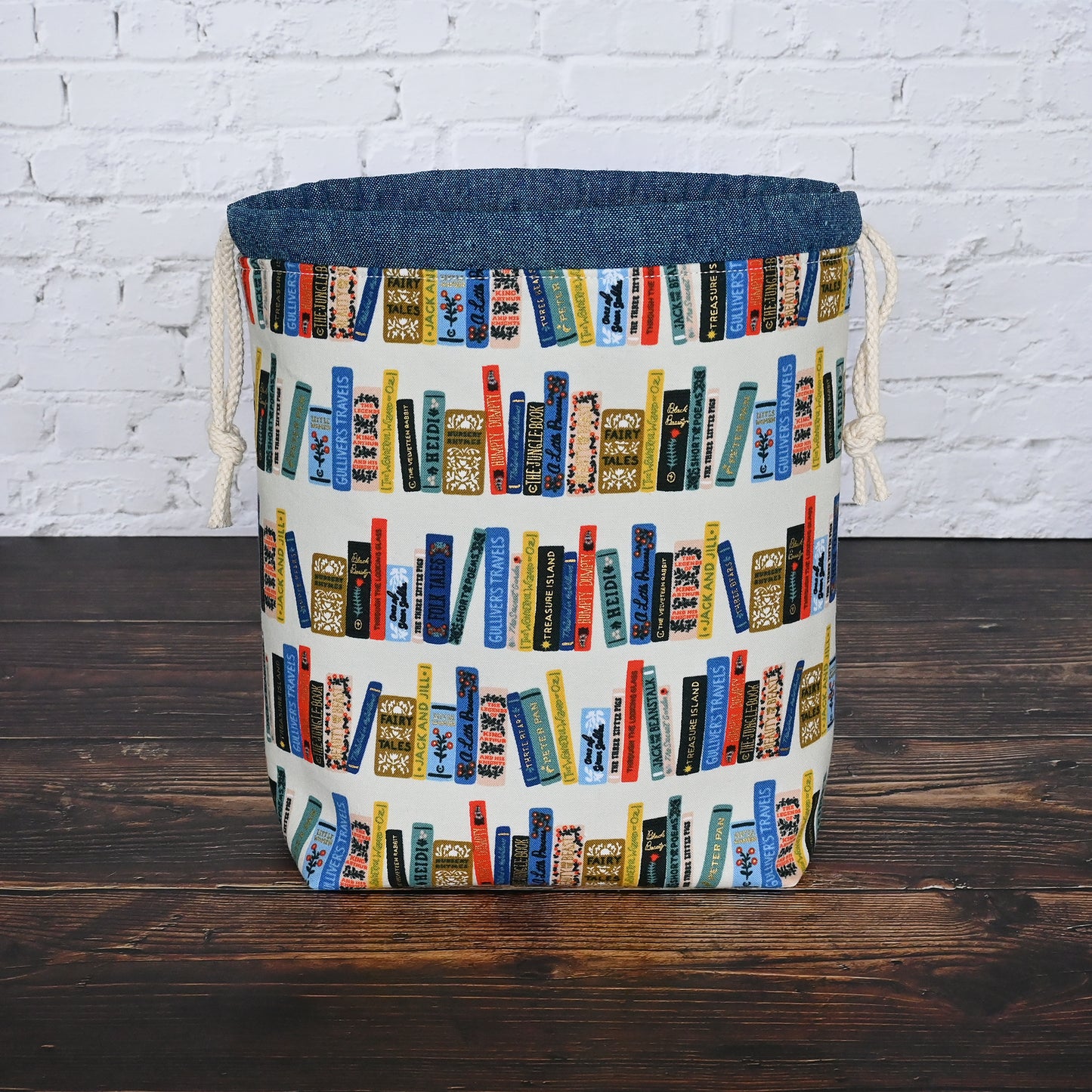 Book Club drawstring project bag from Rifle Paper's Curio collection. Lined in a pretty blue and white striped cotton. Made in Canada by Yellow Petal Handmade.