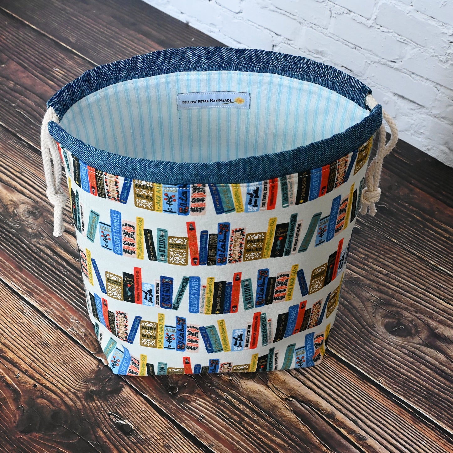 Book Club drawstring project bag from Rifle Paper's Curio collection. Lined in a pretty blue and white striped cotton. Made in Canada by Yellow Petal Handmade.