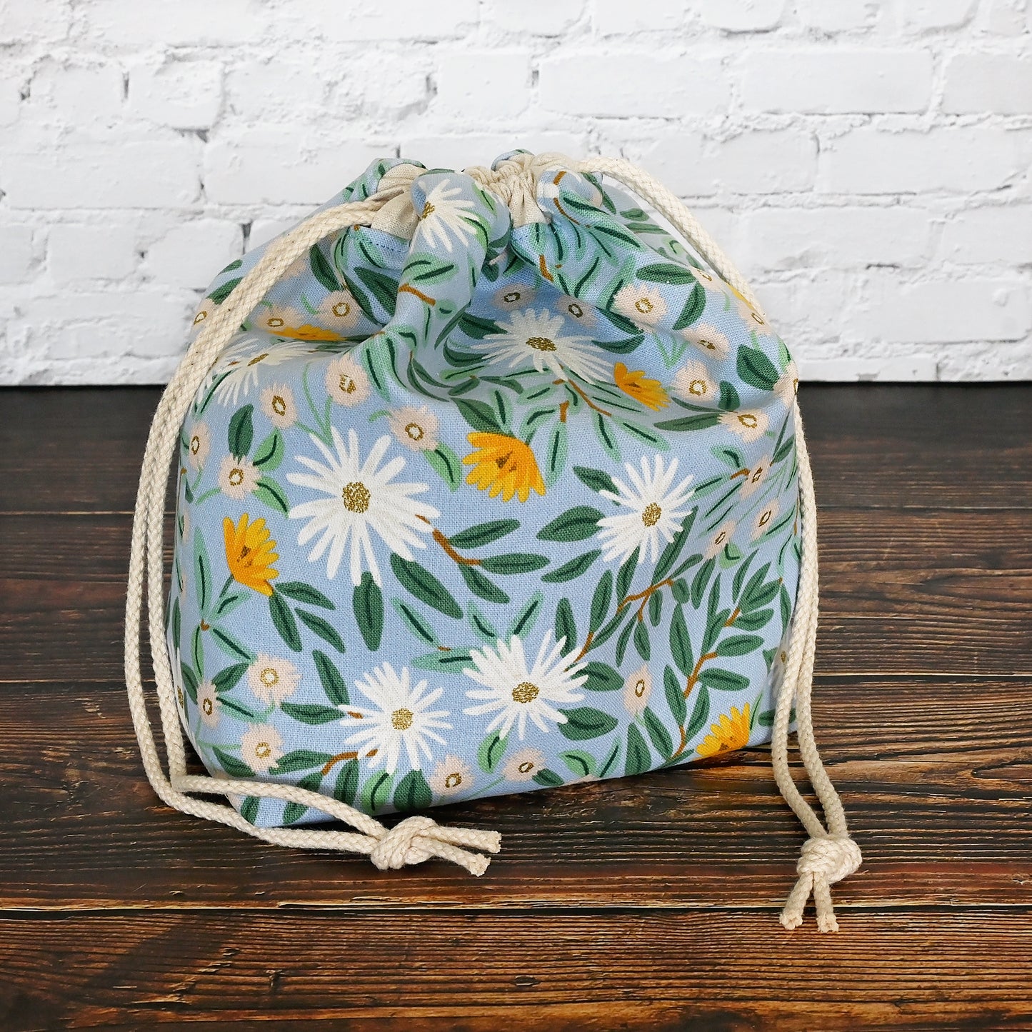 Pretty blue floral project bag made from a lovely canvas by Rifle Paper Co. Lined in a pretty aqua and closes securely with a double drawstring. Perfect for small knitting or crochet projects. Made in Canada by Yellow Petal Handmade.