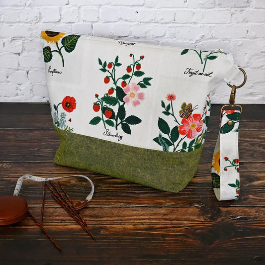 Stunning white canvas floral project bag, paired with a lovely green linen.  This bag has pockets, closes with a zipper and has a lovely removable wrist strap.  Made in Canada by Yellow Petal Handmade.