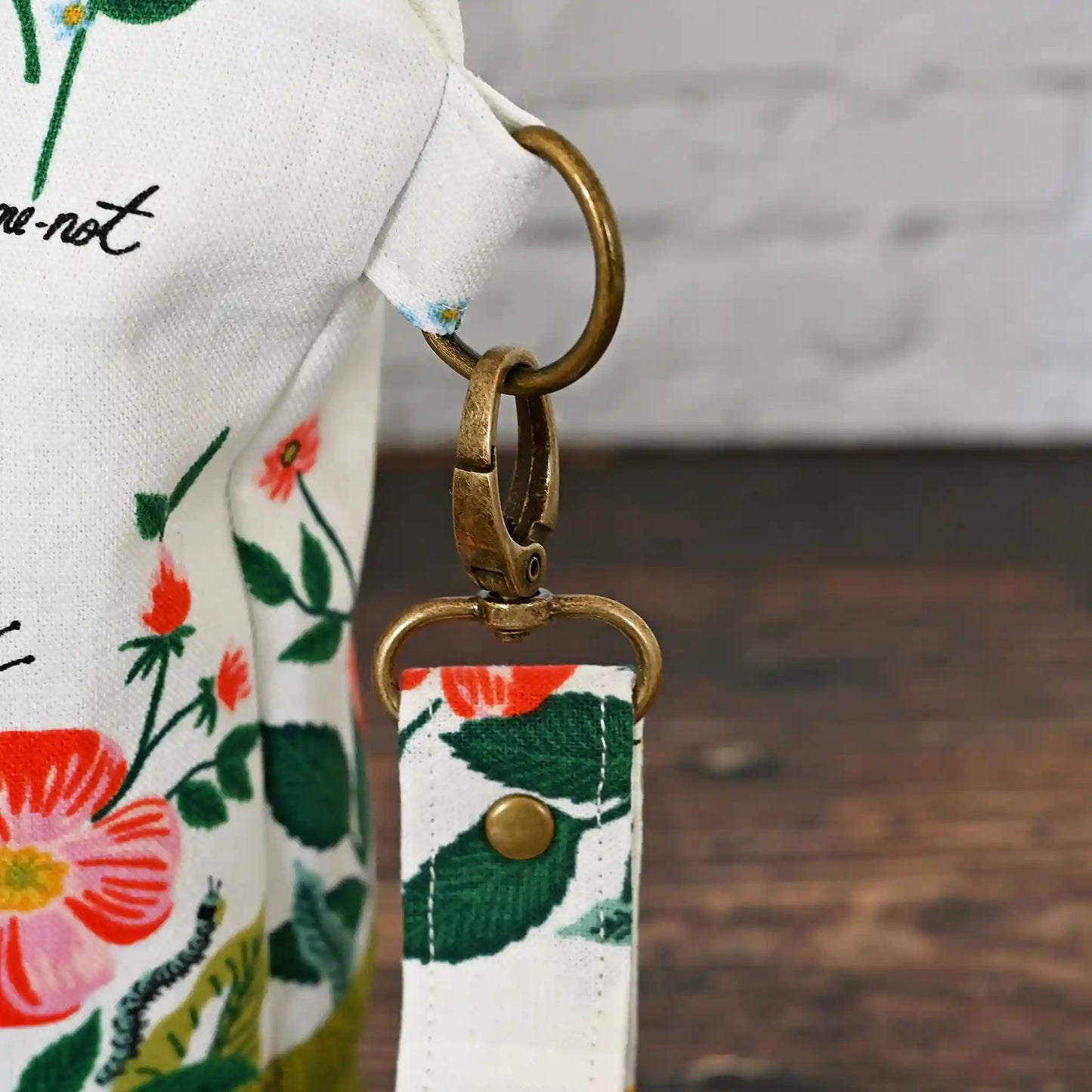 Stunning white canvas floral project bag, paired with a lovely green linen. This bag has pockets, closes with a zipper and has a lovely removable wrist strap. Made in Canada by Yellow Petal Handmade.