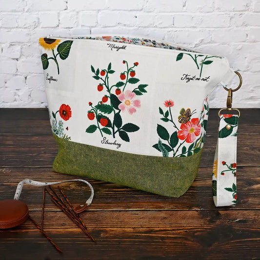 Stunning white canvas floral project bag, paired with a lovely green linen.  This bag has pockets, closes with a zipper and has a lovely removable wrist strap.  Made in Canada by Yellow Petal Handmade.