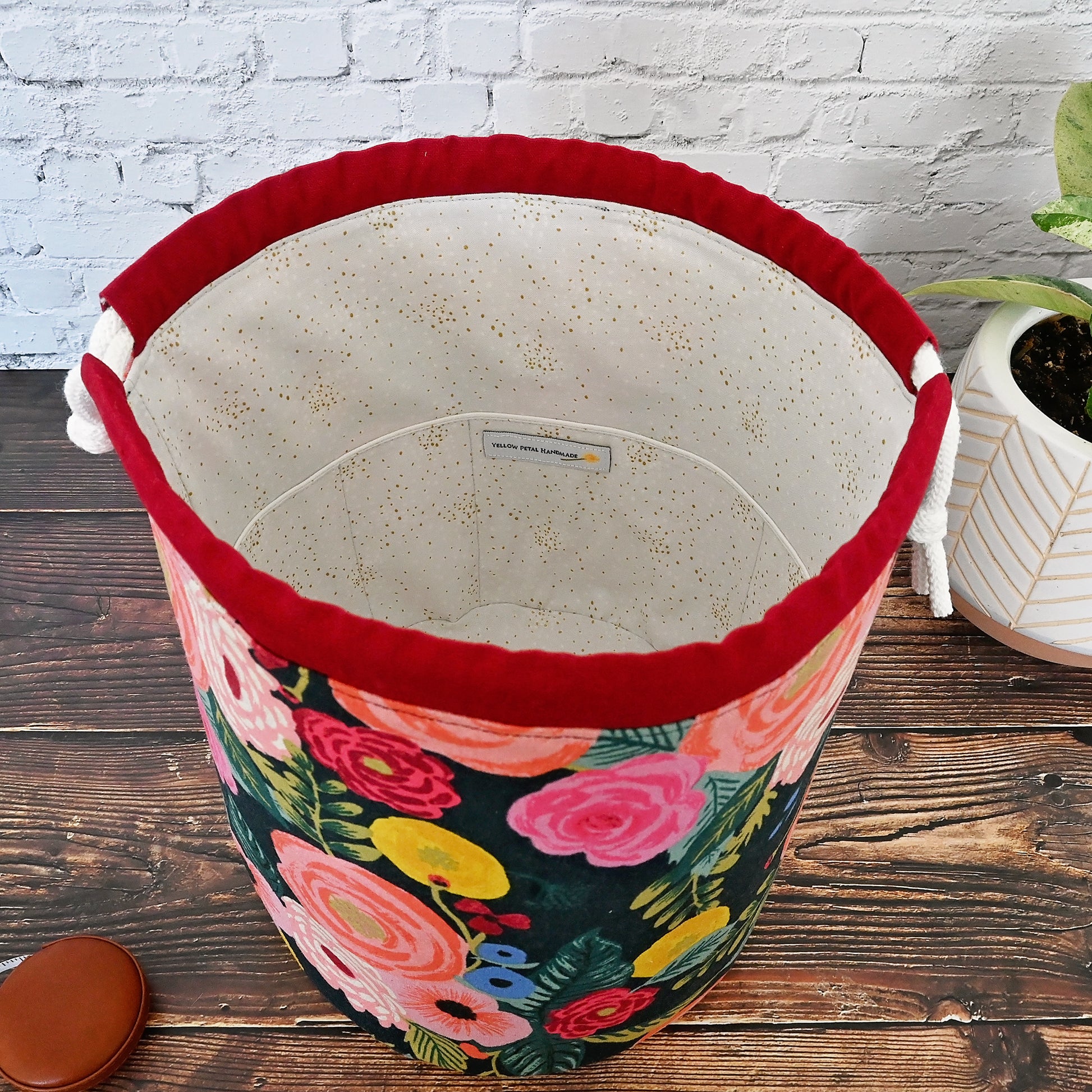 Beautiful canvas bucket bag for knitting or crochet projects.  Made from Rifle Paper Co's English Garden collection, this bag features a dark background with brightly colour flowers on the exterior.  The drawstring casing is made from a pretty burgundy linen and the bag is lined in a lovely dove coloured cotton with gold accents.  This bag features many interior pockets and folds down nicely while using for eacy access.