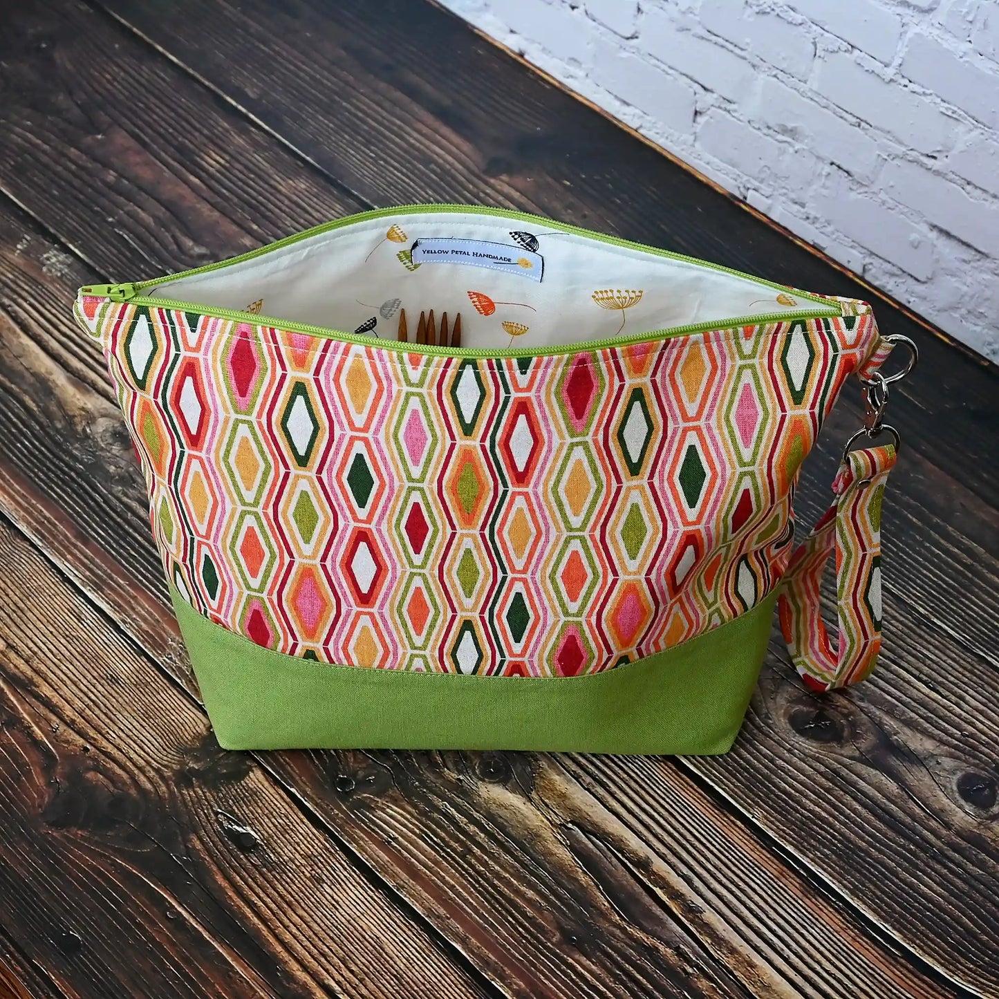 Beautiful jewel toned project bag in an eye catching retro fabric and paired with a beautiful green linen. Made in Canada by Yellow Petal Handmade.