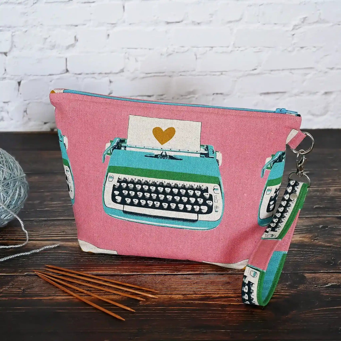 Fun project bag in a fun pink vintage typewriter canvas and lined in a cotton from the same collection. Comes with a removable wrist strap. Made in Canada by Yellow Petal Handmade.
