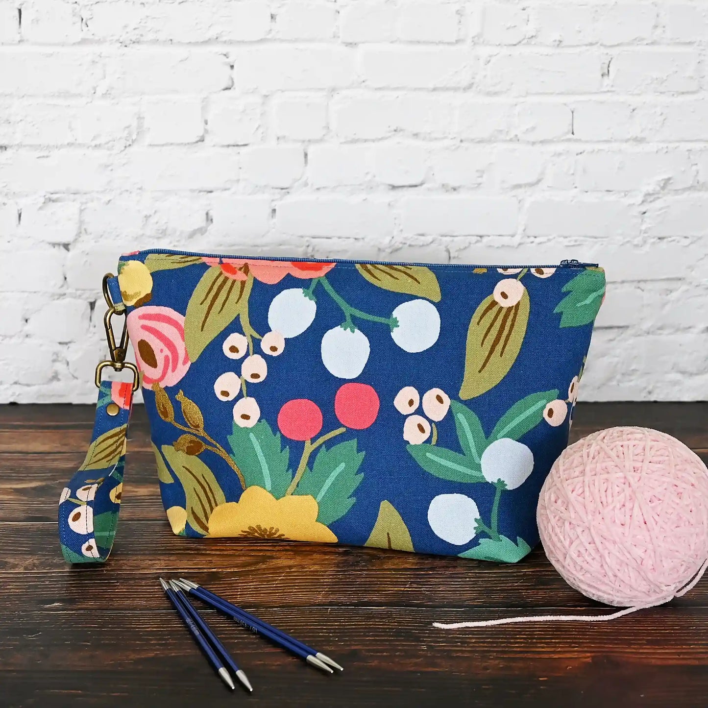 Blue floral canvas zippered pouch with removable wrist strap, lined in a pretty pink cotton. Made with fabric from Rifle Paper Co and Riley Blake. Handmade in Canada by Yellow Petal Handmade.