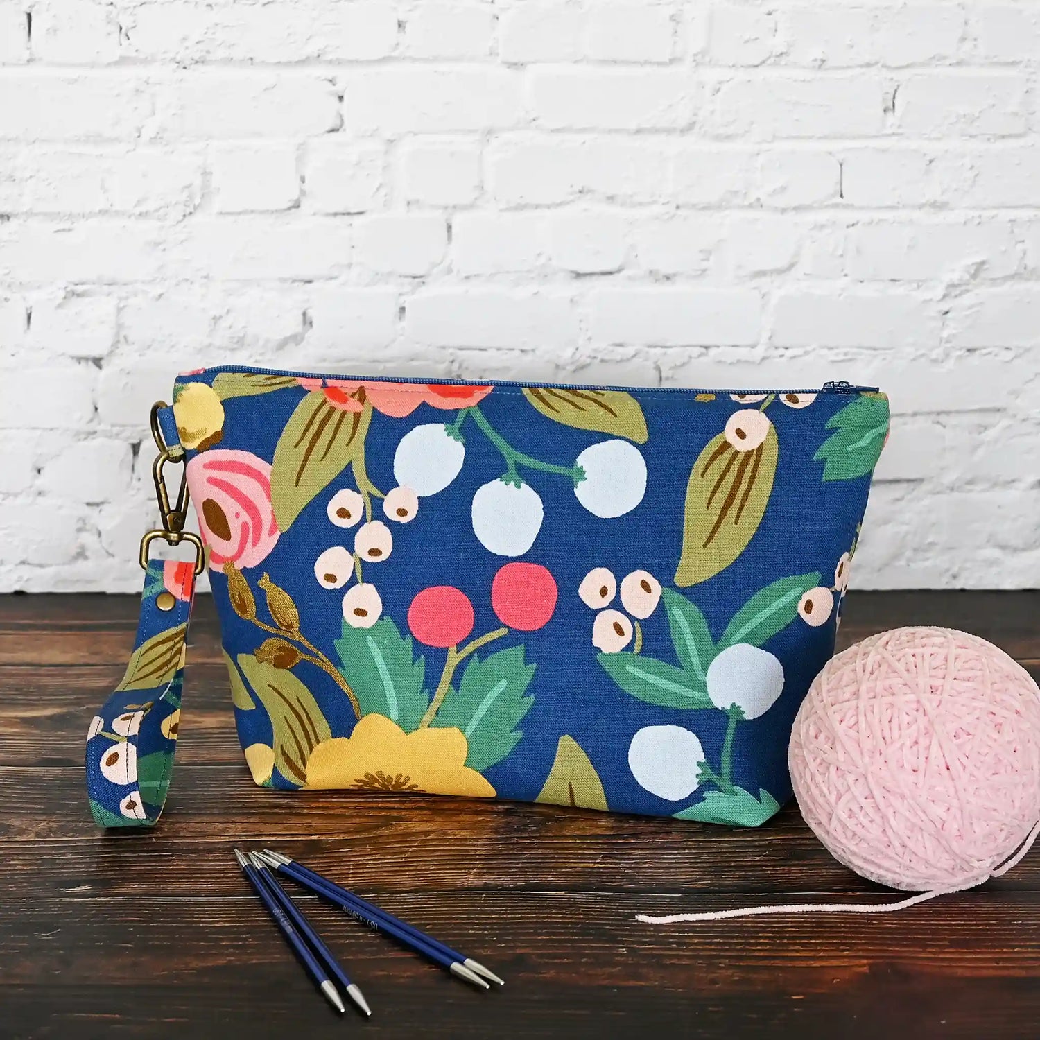 Blue floral canvas zippered pouch with removable wrist strap, lined in a pretty pink cotton.  Made with fabric from Rifle Paper Co and Riley Blake.  Handmade in Canada by Yellow Petal Handmade.