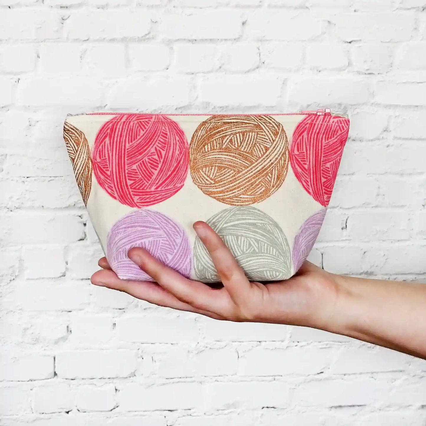 Cute Yarn Balls canvas pouch measuring 8" wide by 5" tall and with a 3.5" boxed bottom. Fabric has cute yarn balls with metallic copper detailing. Made in Canada by Yellow Petal Handmade.