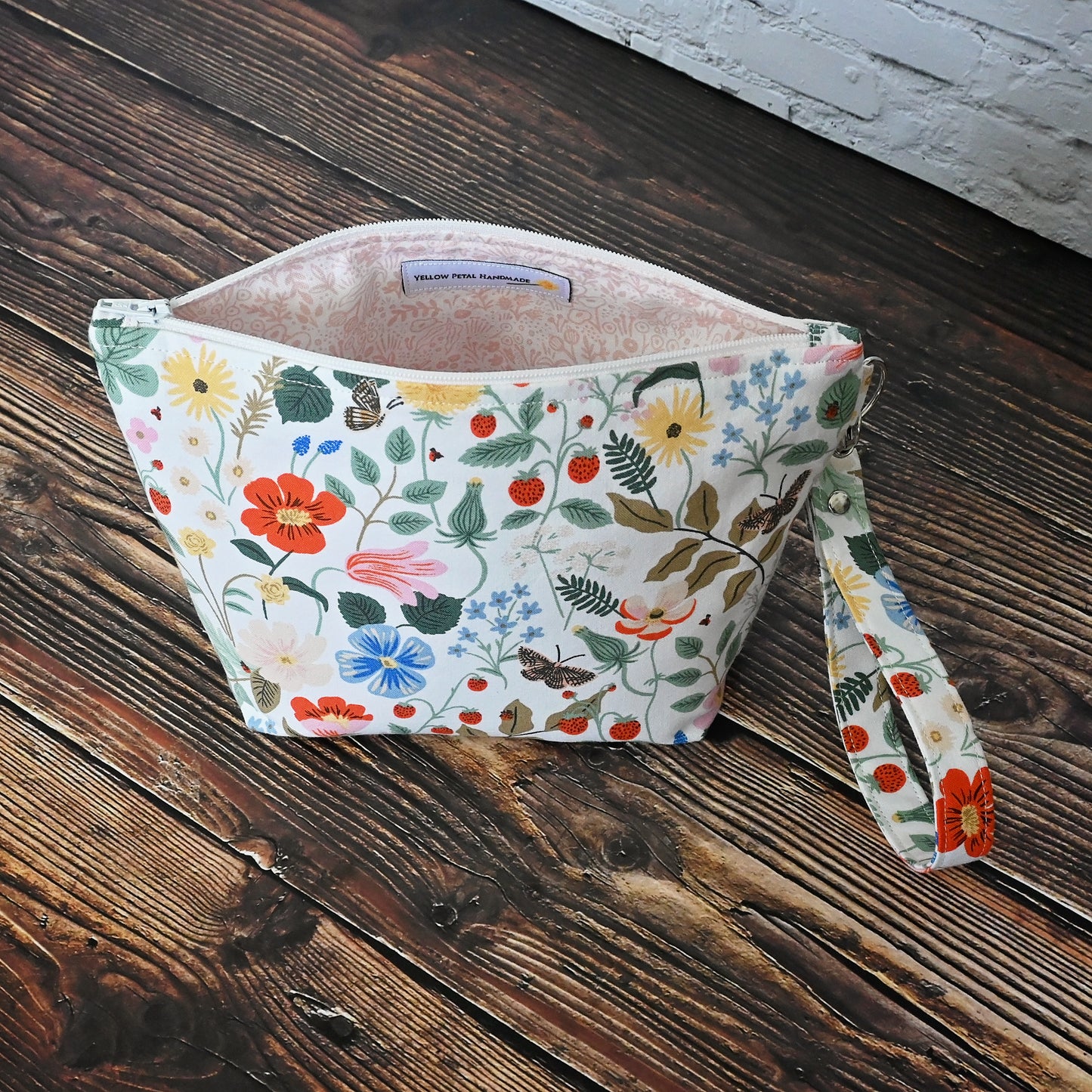 Pretty floral pouches in Rifle Paper Co's Strawberry Fields fabric. Lined with a pretty pink and white floral lining. These bags come with a removable wrist strap and a perfect for carrying small projects.