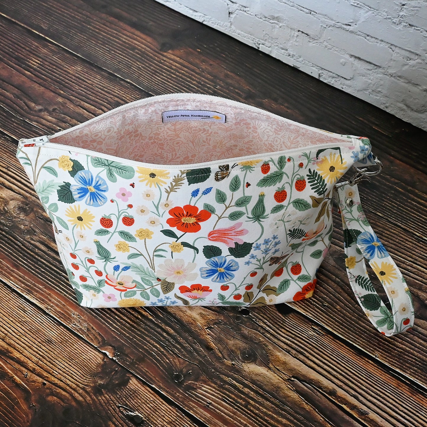 Pretty floral pouches in Rifle Paper Co's Strawberry Fields fabric. Lined with a pretty pink and white floral lining. These bags come with a removable wrist strap and a perfect for carrying small projects.