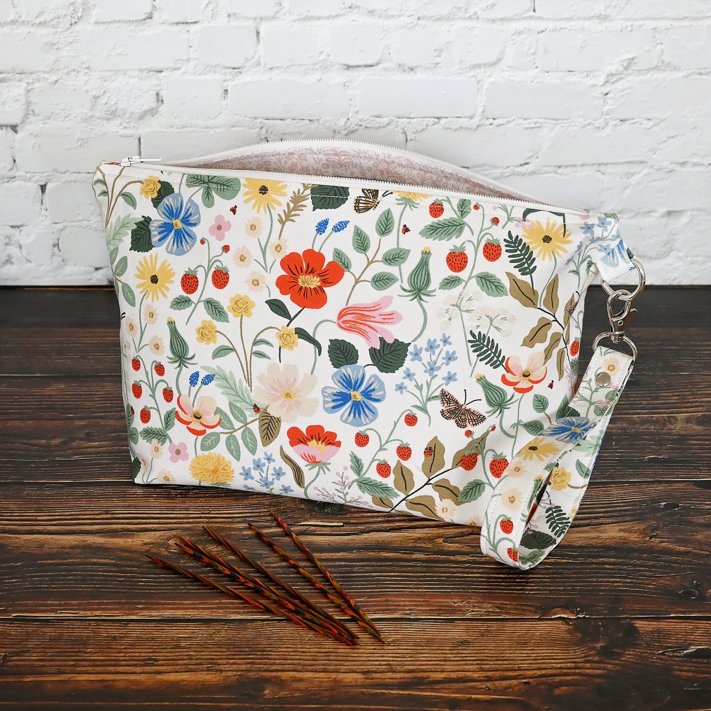 Pretty floral pouches in Rifle Paper Co's Strawberry Fields fabric. Lined with a pretty pink and white floral lining. These bags come with a removable wrist strap and a perfect for carrying small projects.