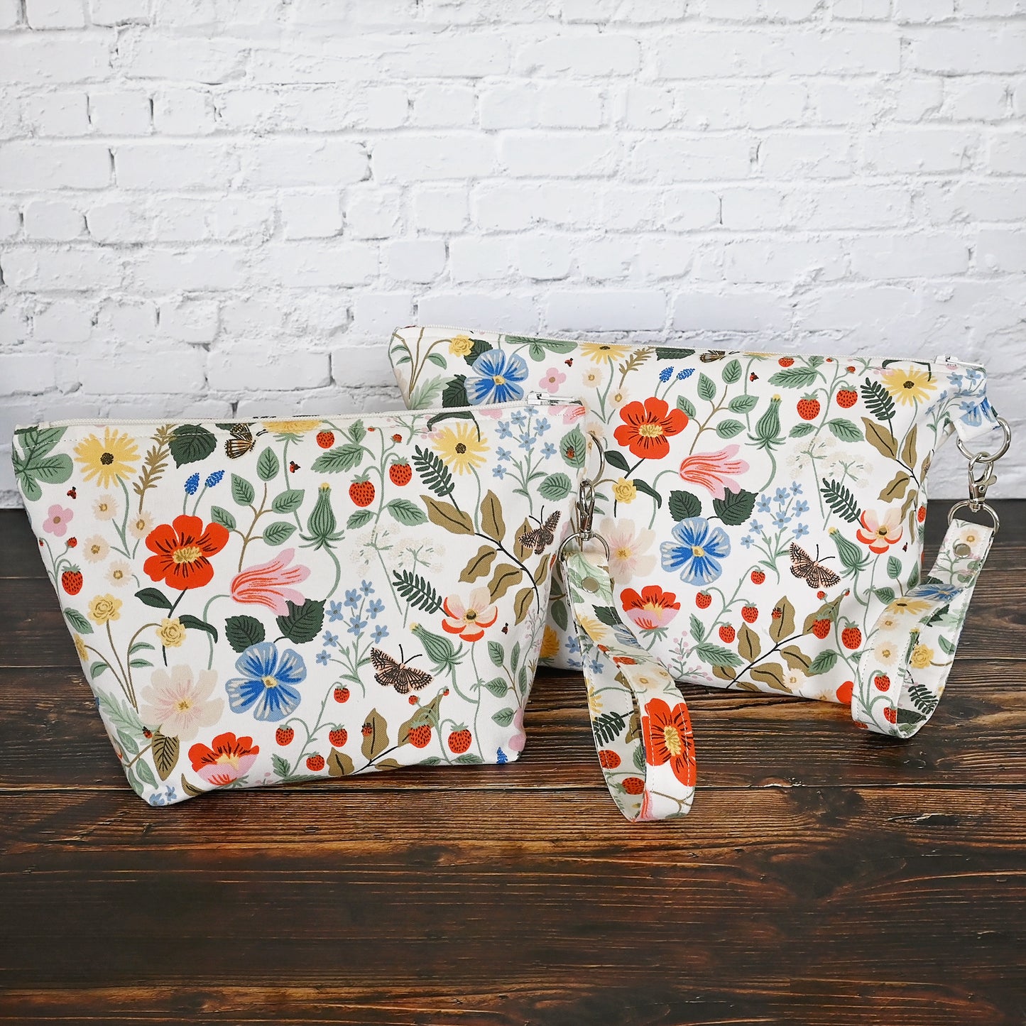 Pretty floral pouches in Rifle Paper Co's Strawberry Fields fabric. Lined with a pretty pink and white floral lining. These bags come with a removable wrist strap and a perfect for carrying small projects.