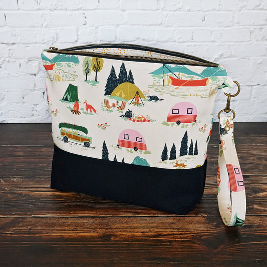 Fun Vintage Camper themed zippered project bag.  Made with a cream cotton in a camping pattern and paired with a navy linen on the bottom.  This bag has a removable wrist strap and a fun dotty fabric lining with interior pockets.  Made in Canada.