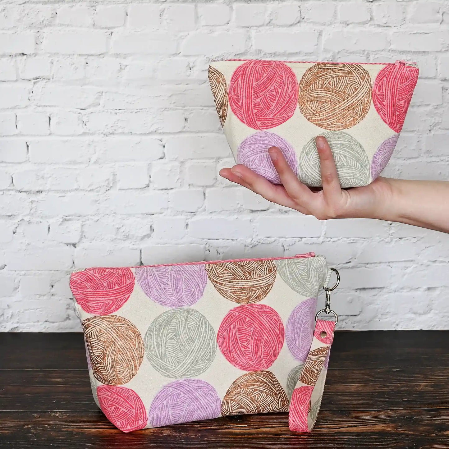 Cute Yarn Balls canvas pouch measuring 8" wide by 5" tall and with a 3.5" boxed bottom. Fabric has cute yarn balls with metallic copper detailing. Made in Canada by Yellow Petal Handmade.