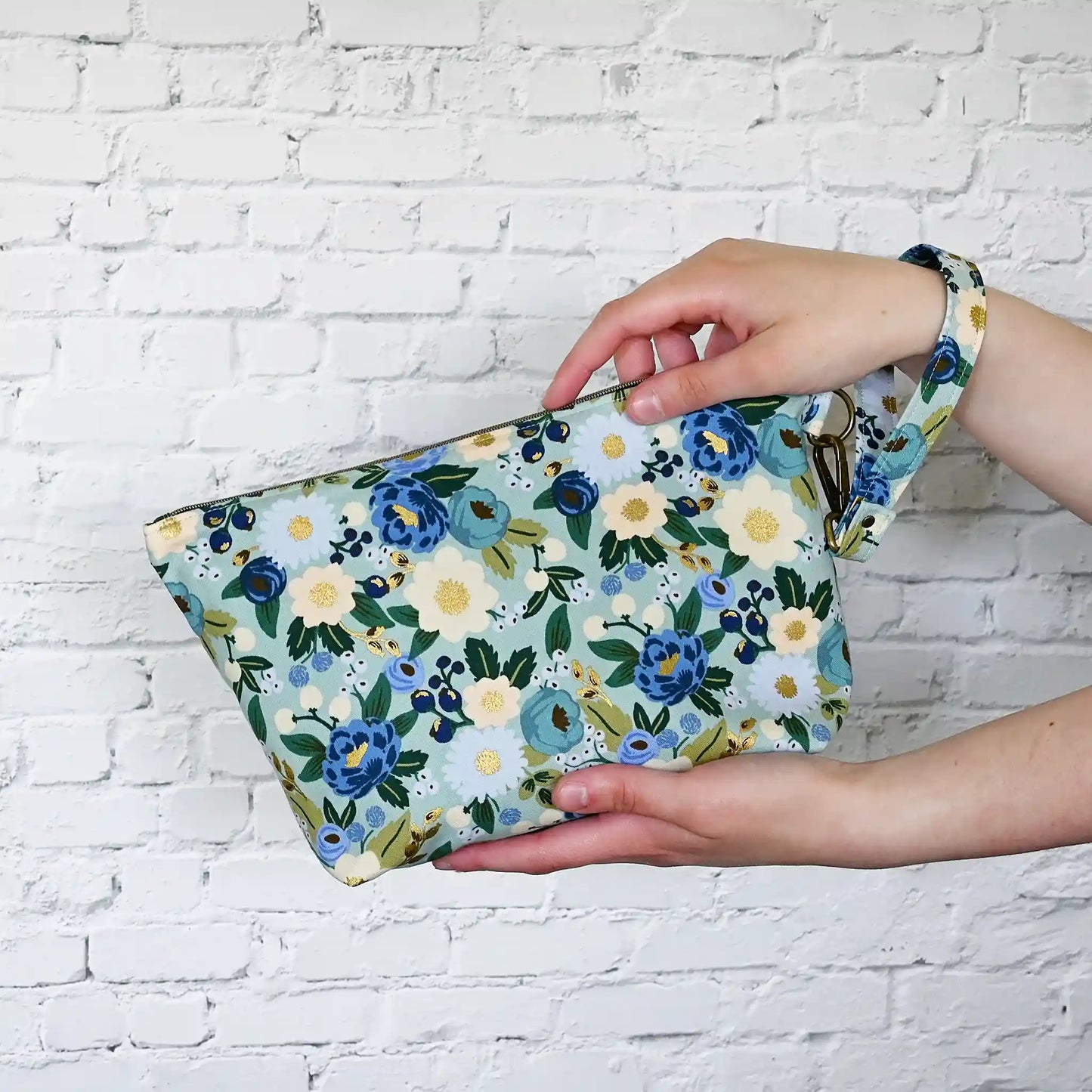 Beautiful pouch in an aqua floral fabric with gold detailing by Rifle Paper Co. Handmade in Nova Scotia, Canada by Yellow Petal Handmade.