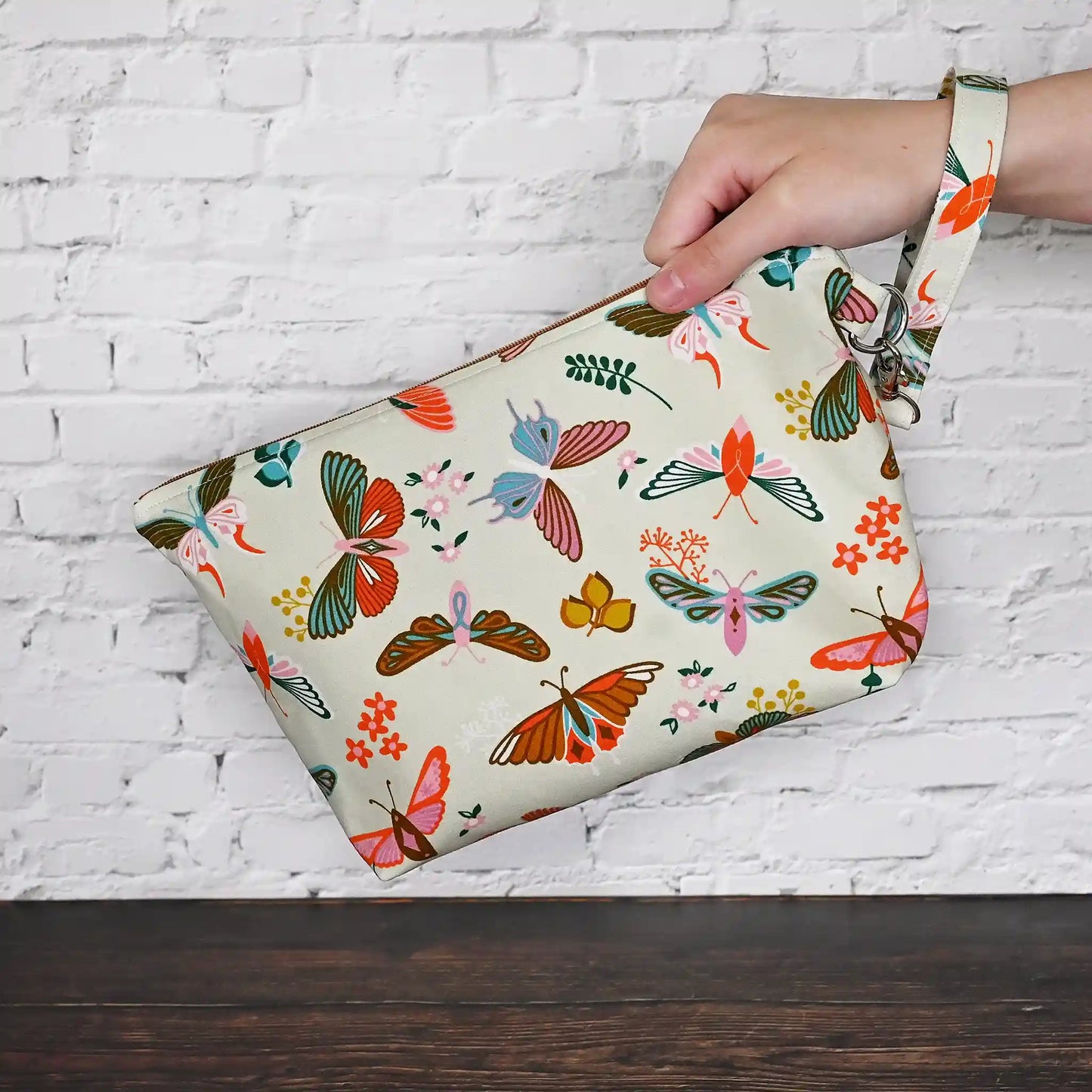 Gorgeous cream pouch with removable strap. Made from a striking butterfly patterned cotton and lined in a pretty cream floral, both by Ruby Star Society. Made in Canada by Yellow Petal Handmade.