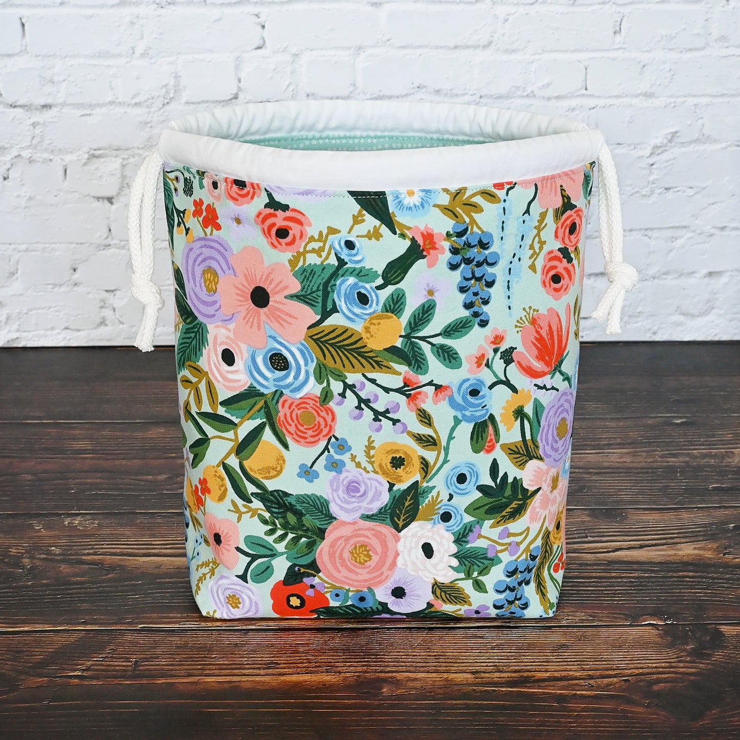 Pretty mint floral drawstring knitting bag made in a lovely cotton from Rifle Paper's newest Garden Party collection. It's lined in a lovely spotted mint cotton and is available with or without pockets. Closes securely with a double drawstring. Made in Canada by Yellow Petal Handmade.