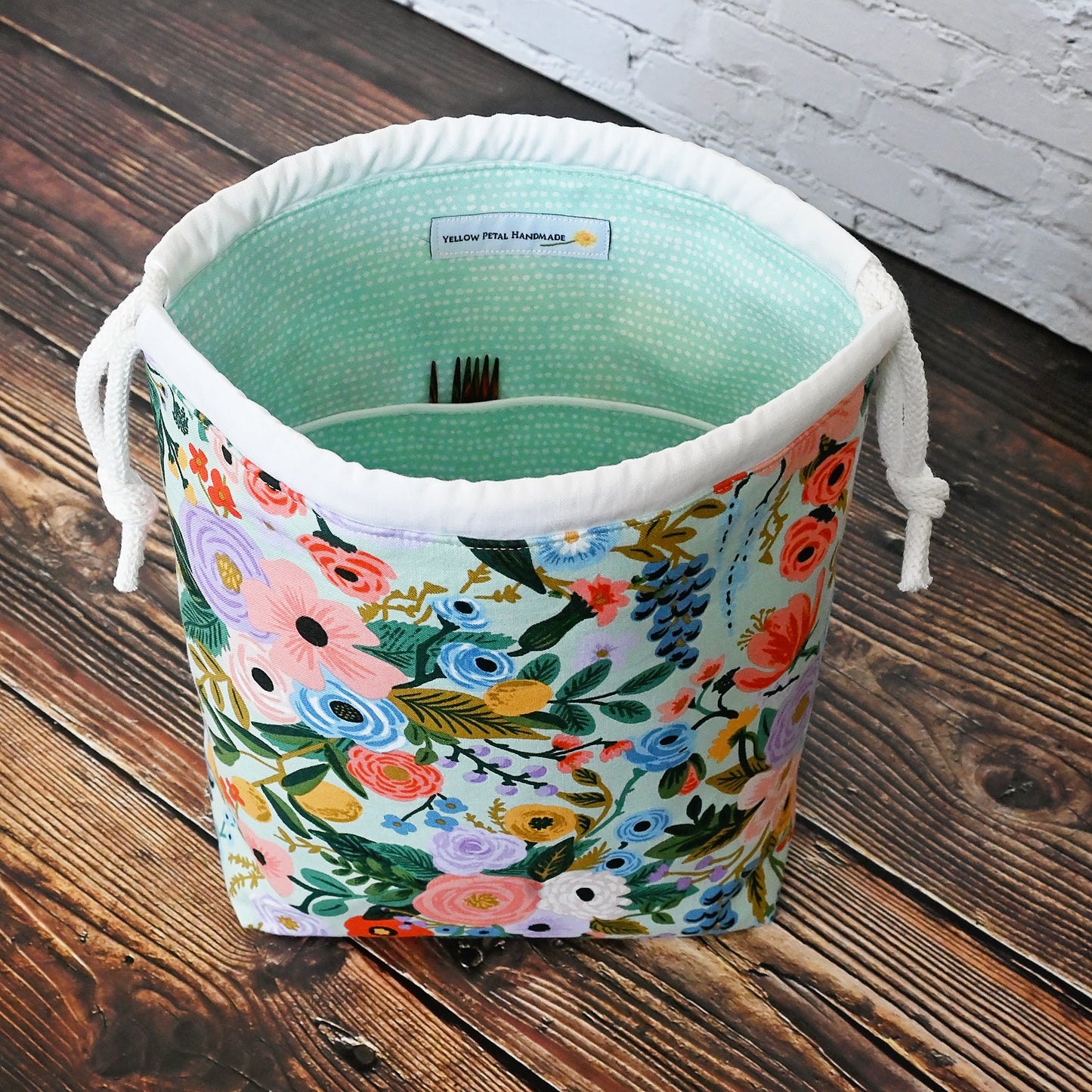 Pretty mint floral drawstring knitting bag made in a lovely cotton from Rifle Paper's newest Garden Party collection. It's lined in a lovely spotted mint cotton and is available with or without pockets. Closes securely with a double drawstring. Made in Canada by Yellow Petal Handmade.