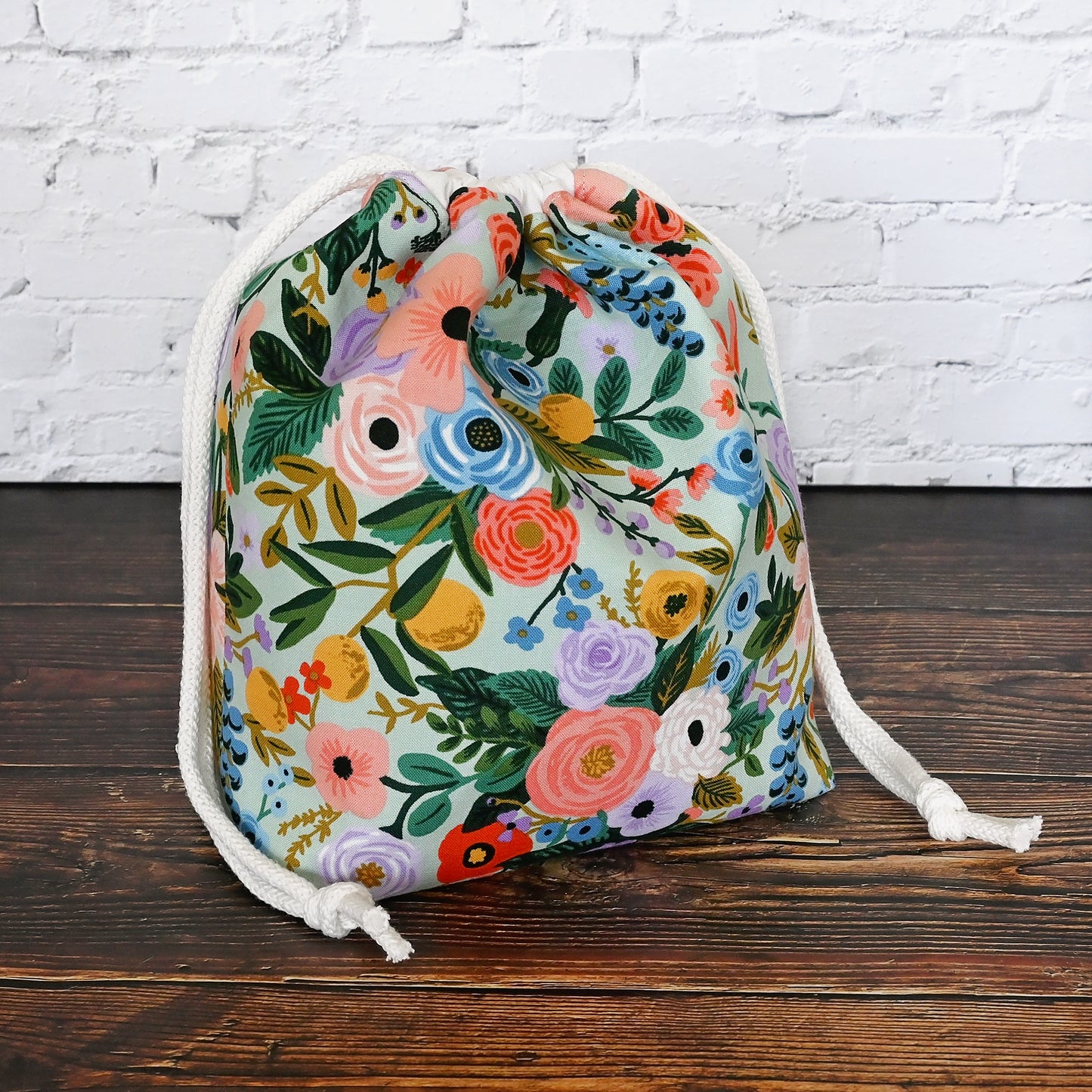 Pretty mint floral drawstring knitting bag made in a lovely cotton from Rifle Paper's newest Garden Party collection. It's lined in a lovely spotted mint cotton and is available with or without pockets. Closes securely with a double drawstring. Made in Canada by Yellow Petal Handmade.