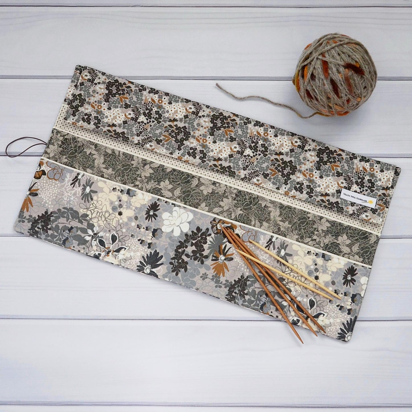 Large knitting needle tri-fold wrap in grey floral with bronze accents. Made by Yellow Petal Handmade in Nova Scotia, Canada.