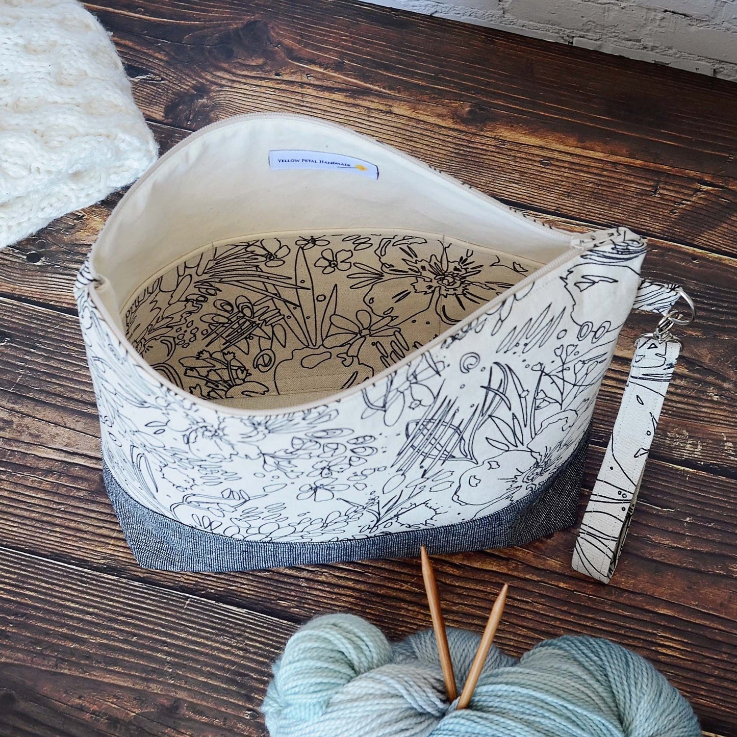 Classic linen zippered project bag for knitting or crochet. Black and beige linens and features a wrist strap. Made in Nova Scotia, Canada by Yellow Petal Handmade.