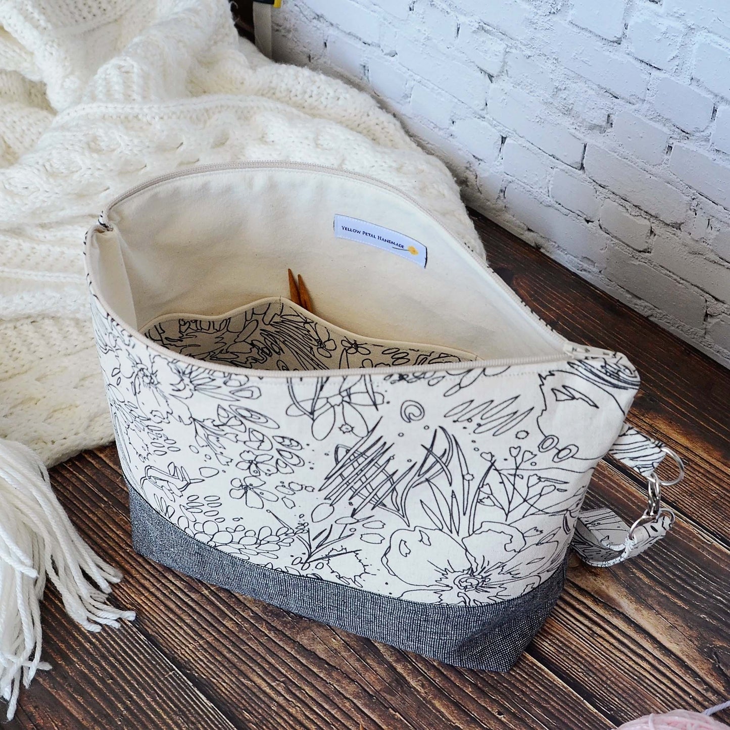 Classic linen zippered project bag for knitting or crochet. Black and beige linens and features a wrist strap. Made in Nova Scotia, Canada by Yellow Petal Handmade.