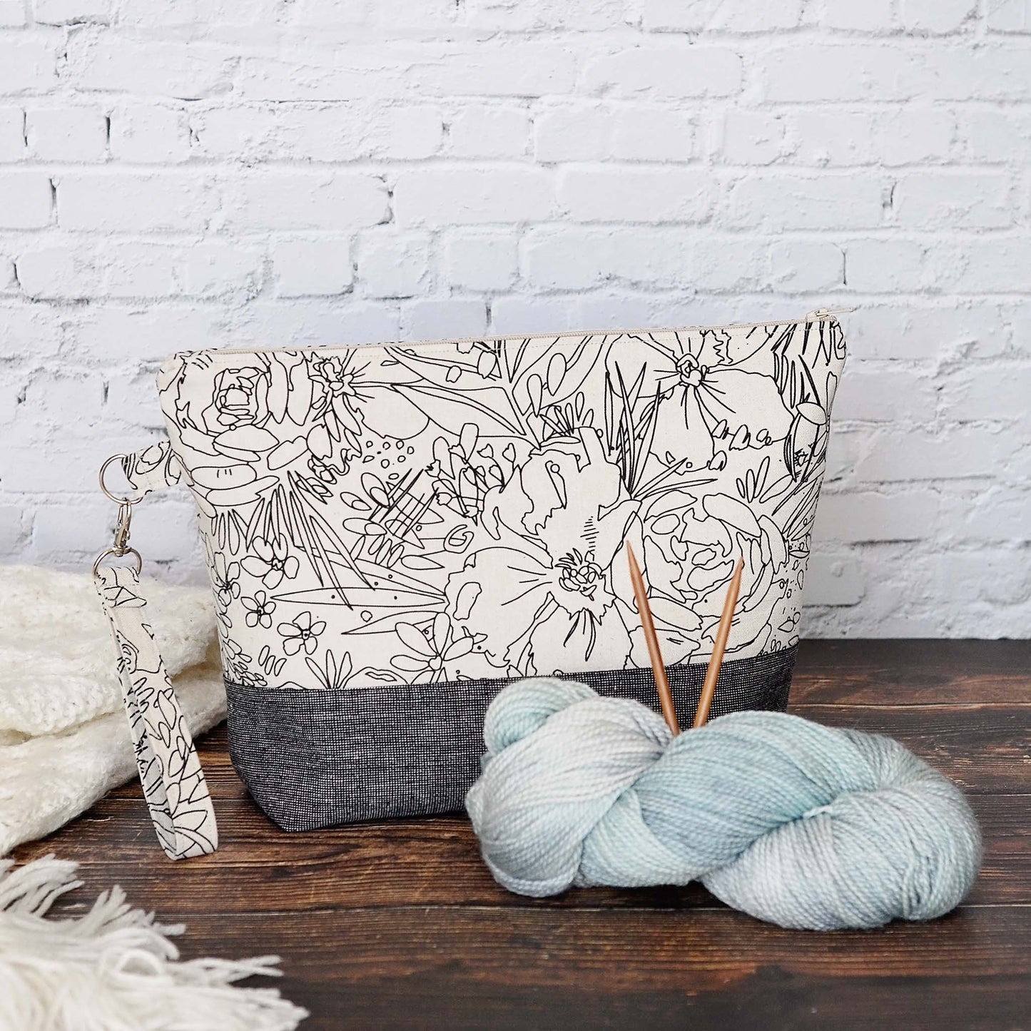 Classic linen zippered project bag for knitting or crochet. Black and beige linens and features a wrist strap. Made in Nova Scotia, Canada by Yellow Petal Handmade.