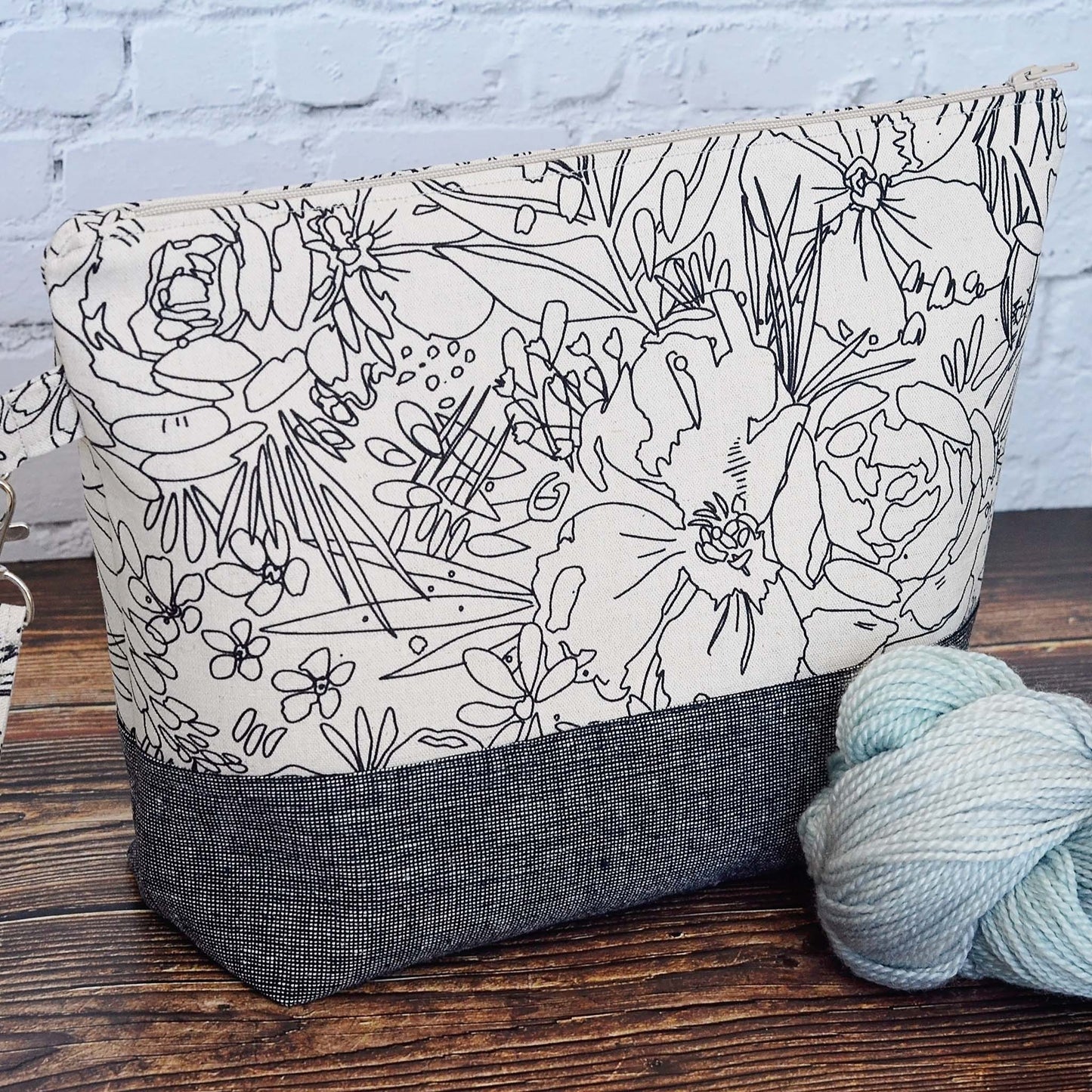 Classic linen zippered project bag for knitting or crochet. Black and beige linens and features a wrist strap. Made in Nova Scotia, Canada by Yellow Petal Handmade.