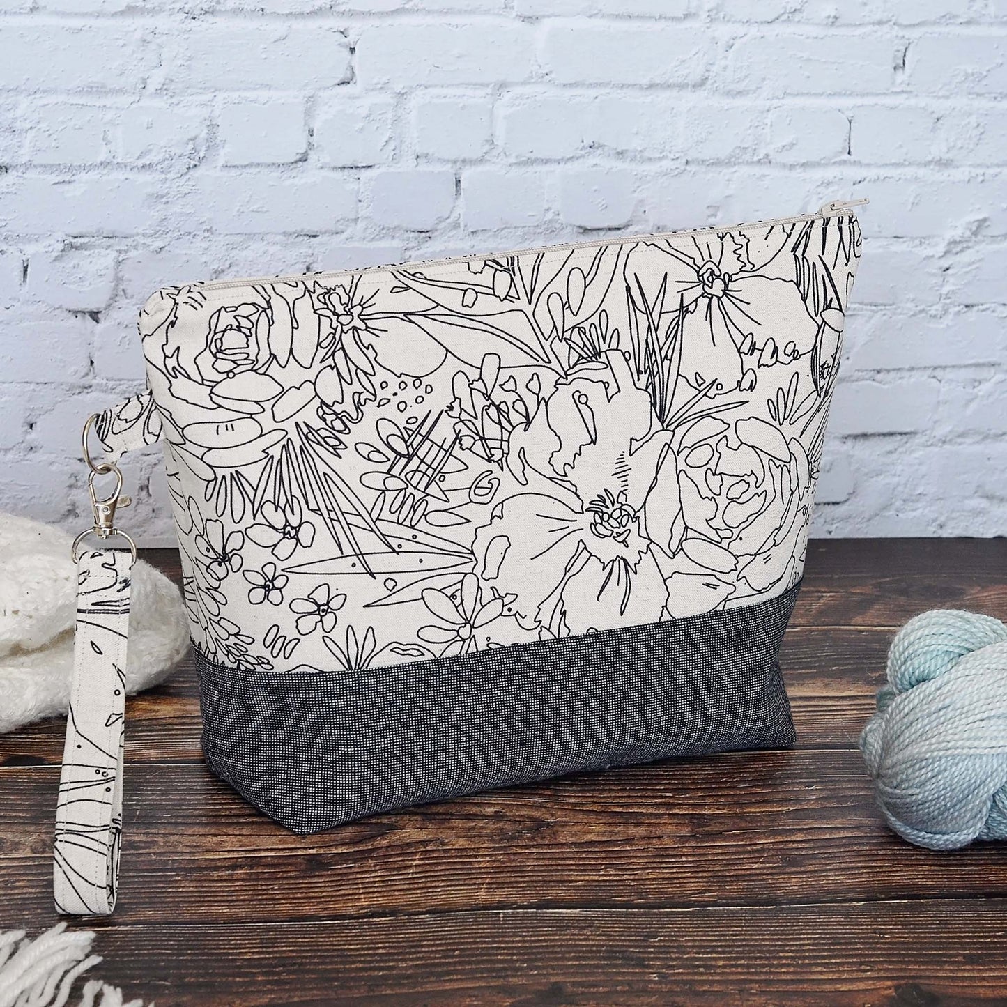 Classic linen zippered project bag for knitting or crochet. Black and beige linens and features a wrist strap. Made in Nova Scotia, Canada by Yellow Petal Handmade.