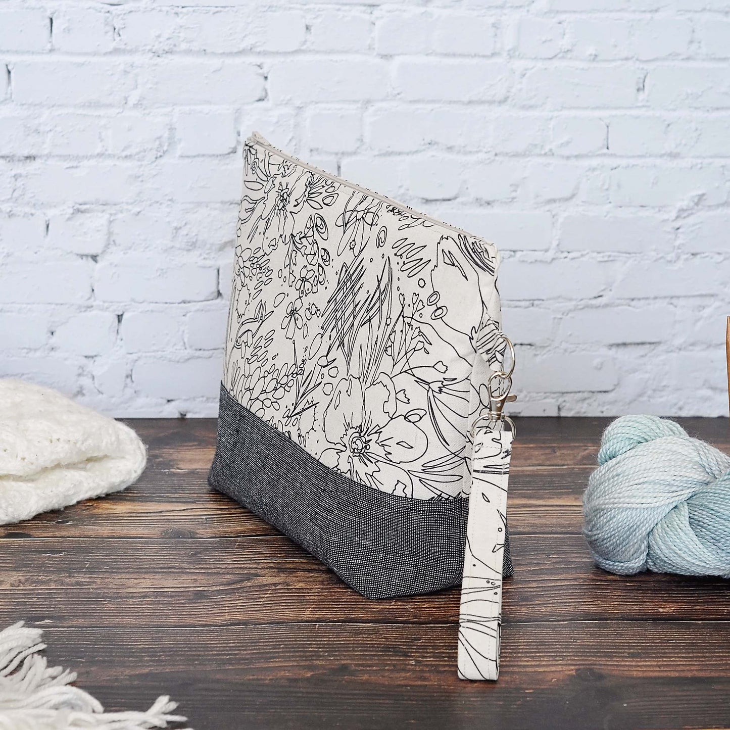 Classic linen zippered project bag for knitting or crochet. Black and beige linens and features a wrist strap. Made in Nova Scotia, Canada by Yellow Petal Handmade.