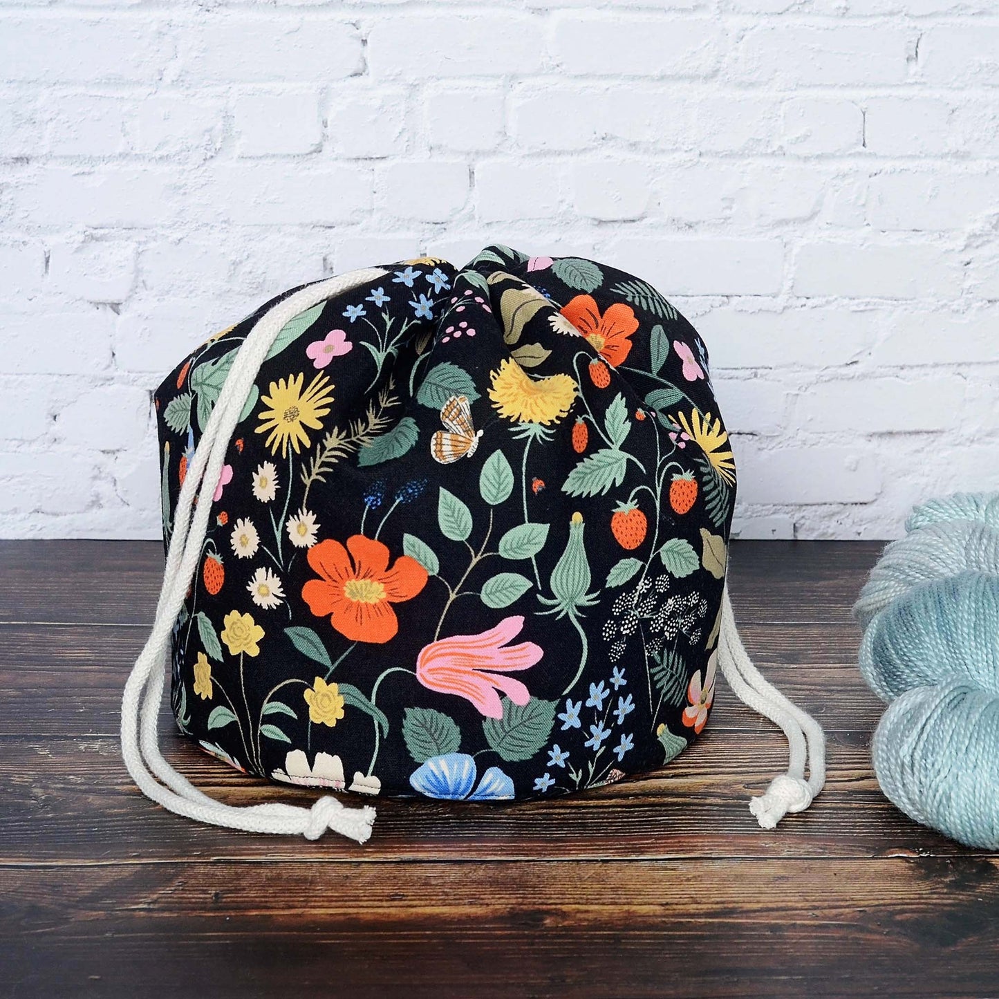 Bucket style knitting bag with multiple pockets.  Made from a black floral canvas from Rifle Paper Co's Strawberry Fields.  Made in Canada by Yellow Petal Handmade.