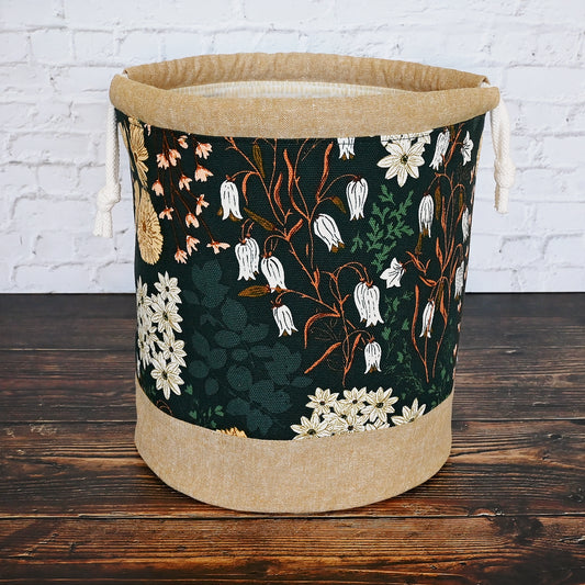 Beautiful dark green floral bucket bag for knitting or crochet projects.  Made from a canvas and paired with a rich linen, this bag features multiple pockets and a quilted bottom for added stability.  Perfect for medium to larger projects.  Made in Canada by Yellow Petal Handmade.