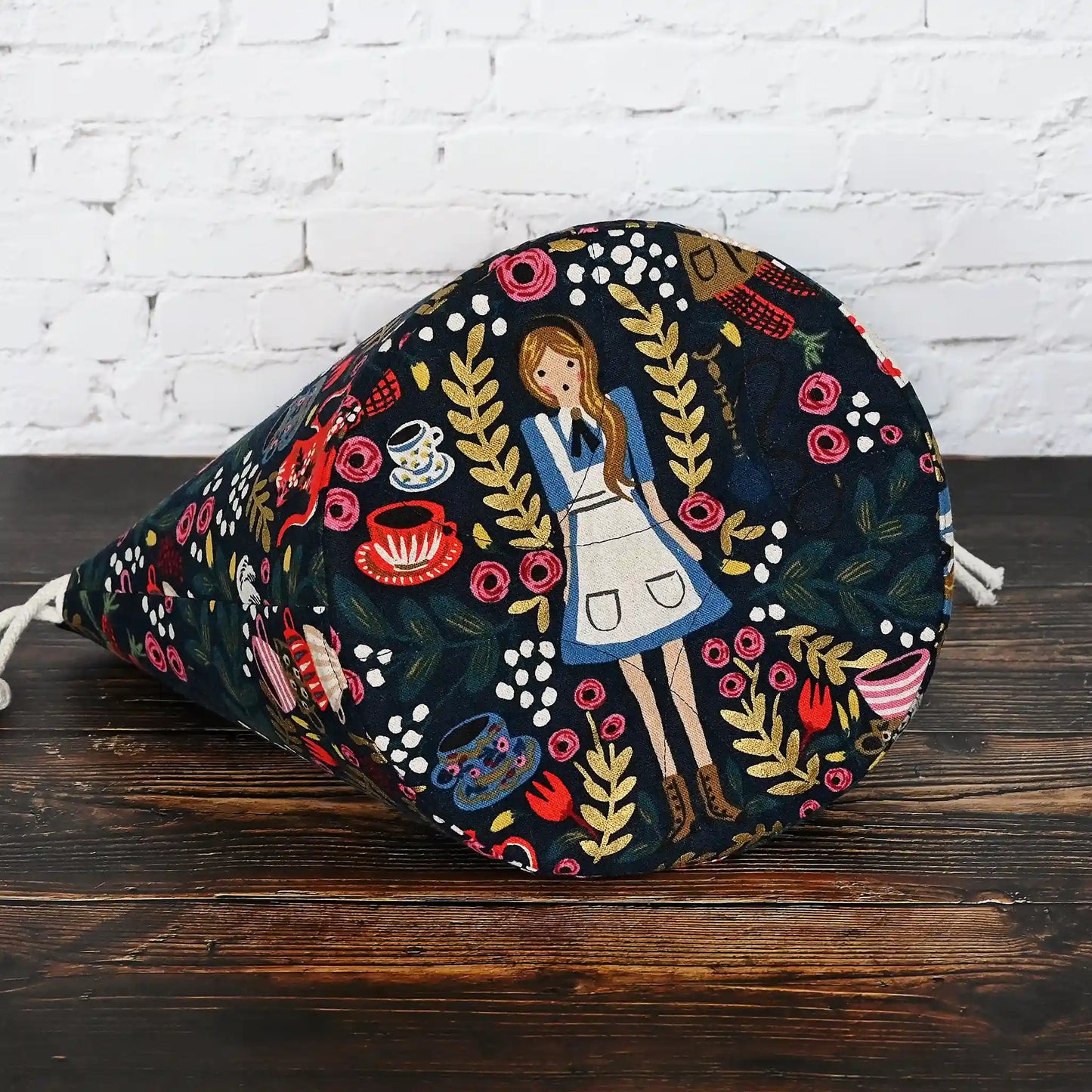 Gorgeous navy bucket bag made from canvas with a beautiful Alice in Wonderland pattern.  It has lots of pockets and is structured to stand alone.  Made in Canada by Yellow Petal Handmade.