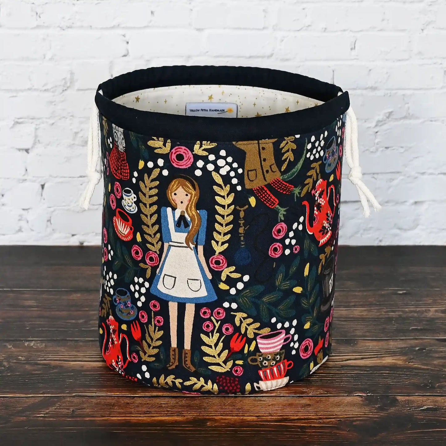 Gorgeous navy bucket bag made from canvas with a beautiful Alice in Wonderland pattern.  It has lots of pockets and is structured to stand alone.  Made in Canada by Yellow Petal Handmade.