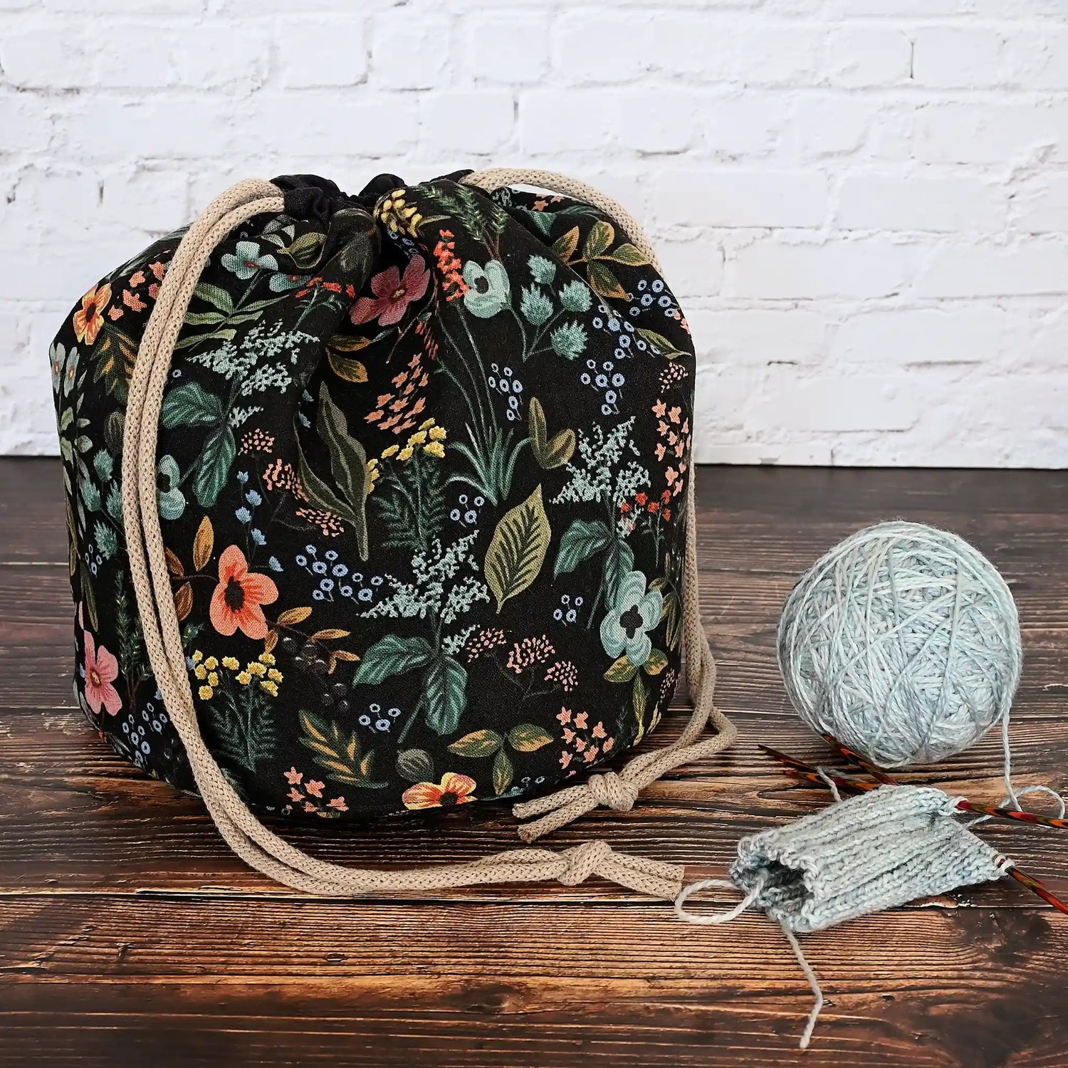 Black floral bucket style project bag with lots of pockets.  Made from Rifle Paper Co's Amalfi canvas, this drawstring bag features a quilted base for design and stability.  Handmade in Canada by Yellow Petal Handmade.