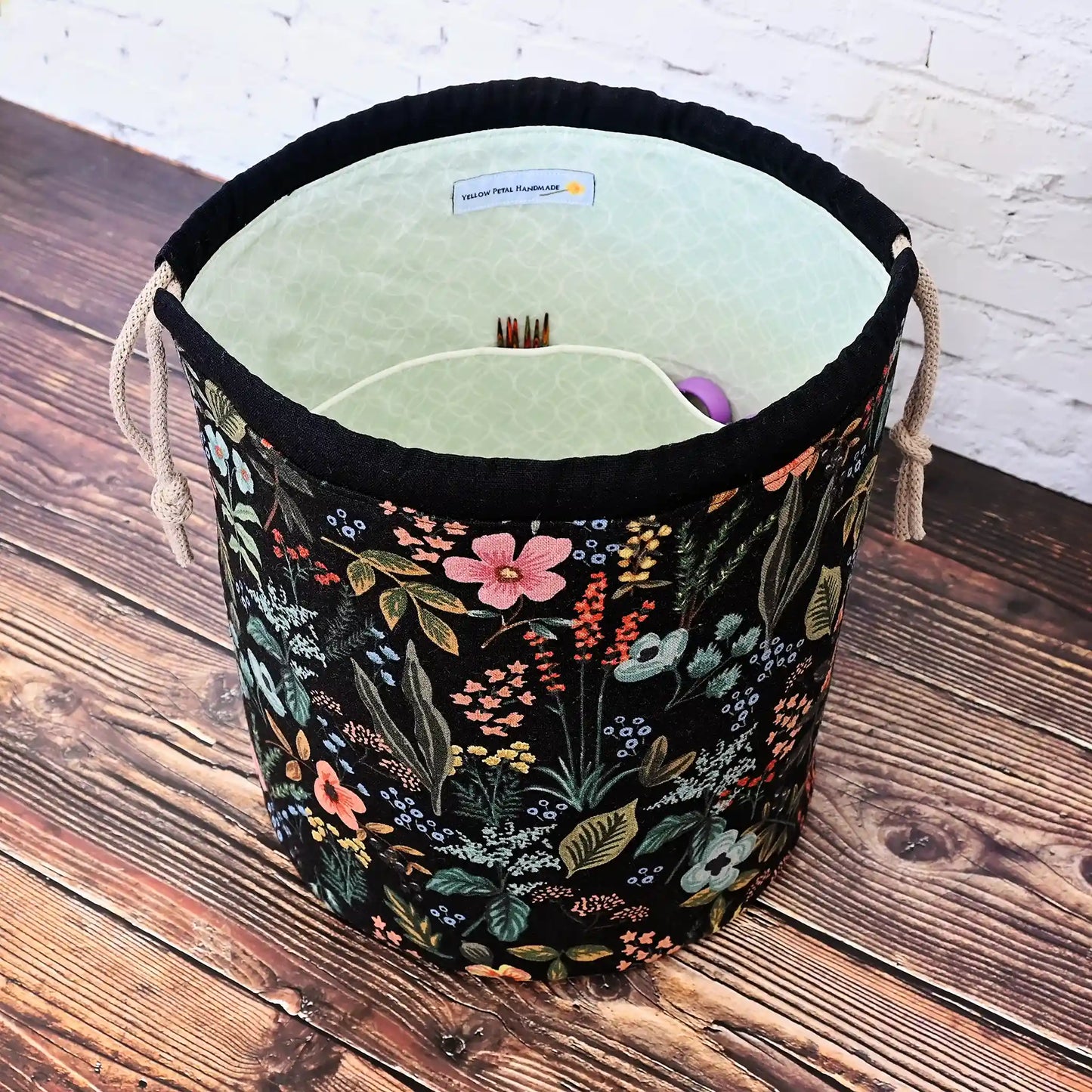 Black floral bucket style project bag with lots of pockets.  Made from Rifle Paper Co's Amalfi canvas, this drawstring bag features a quilted base for design and stability.  Handmade in Canada by Yellow Petal Handmade.