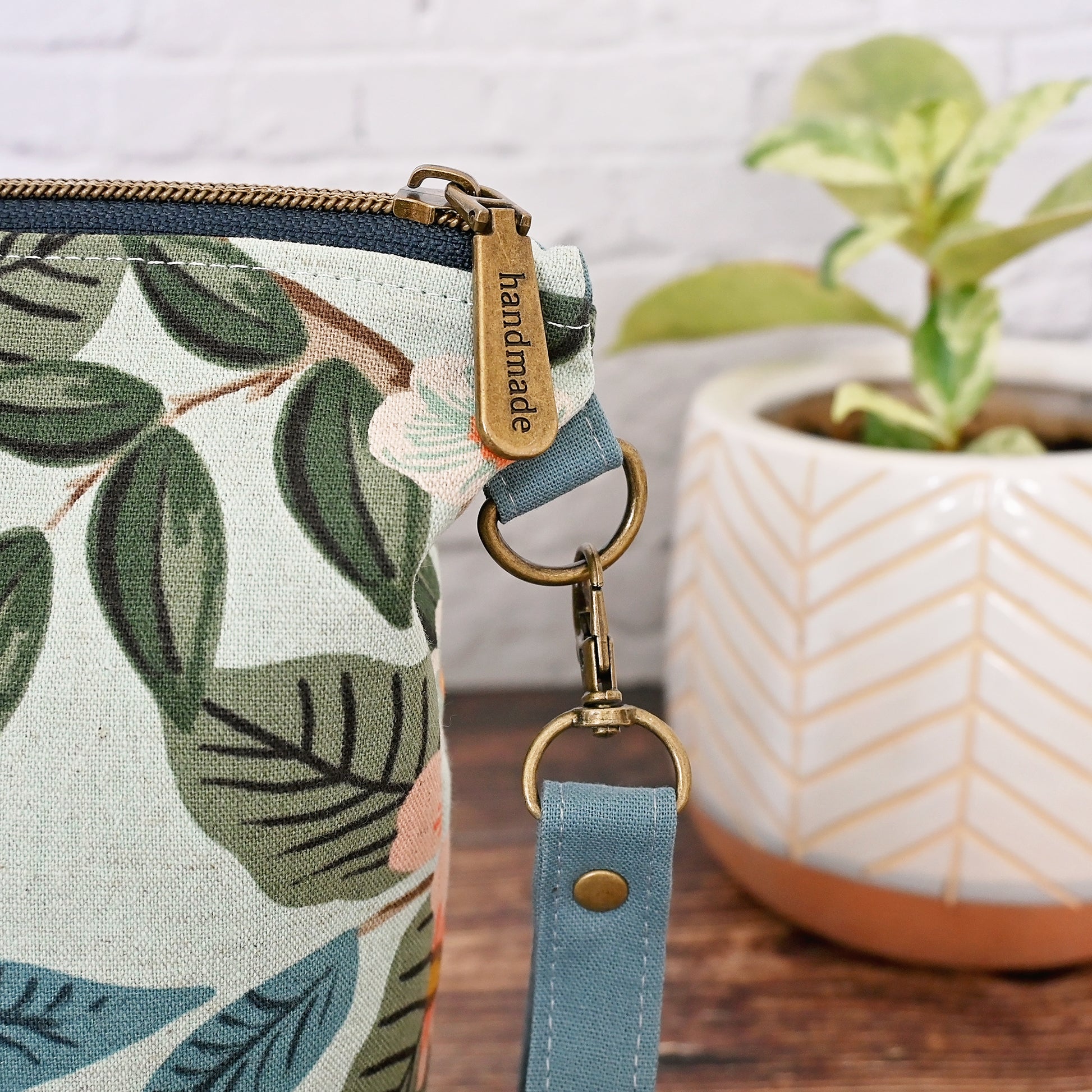 Lovely canvas project bag in Rifle Paper Co's Bramble collection.  Made from an aqua canvas featuring citrus fruit and flowers.  The exterior is paired with a lovely blue grey linen by Robert Kaufman, and the interior, including pockets, is made from a pretty aqua and white cotton.  This bag features a lovely high quality zipper and a removable wrist strap.  Made in Canada by Yellow Petal Handmade.