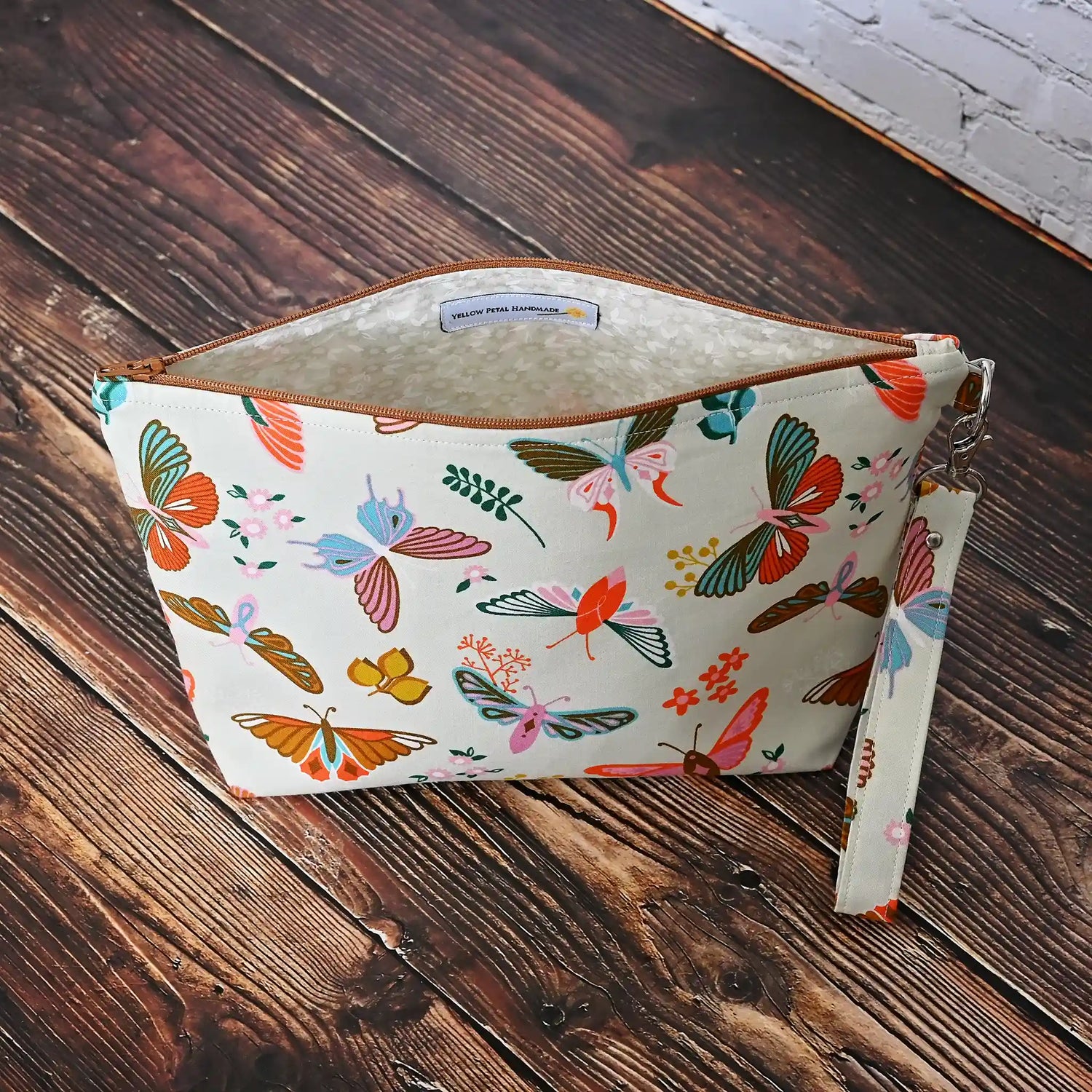 Gorgeous cream pouch with removable strap.  Made from a striking butterfly patterned cotton and lined in a pretty cream floral, both by Ruby Star Society.  Made in Canada by Yellow Petal Handmade.