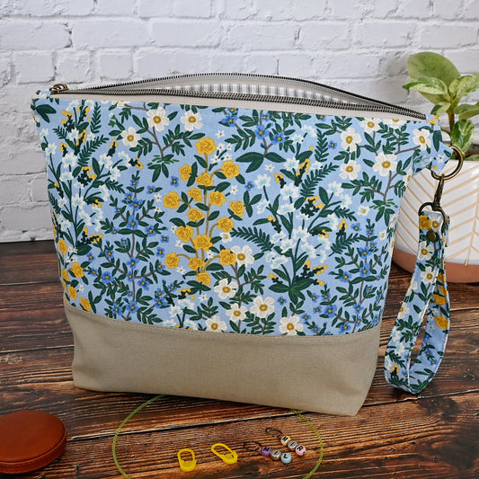 Lovely canvas project bag in Rifle Paper Co's Camont collection.  Made from a pretty blue floral canvas that is paried with a putty coloured linen.  The interior, including pockets, is made from a lovely cream and grey stripe.  This bag features a lovely high quality zipper and a removable wrist strap.  Made in Canada by Yellow Petal Handmade.