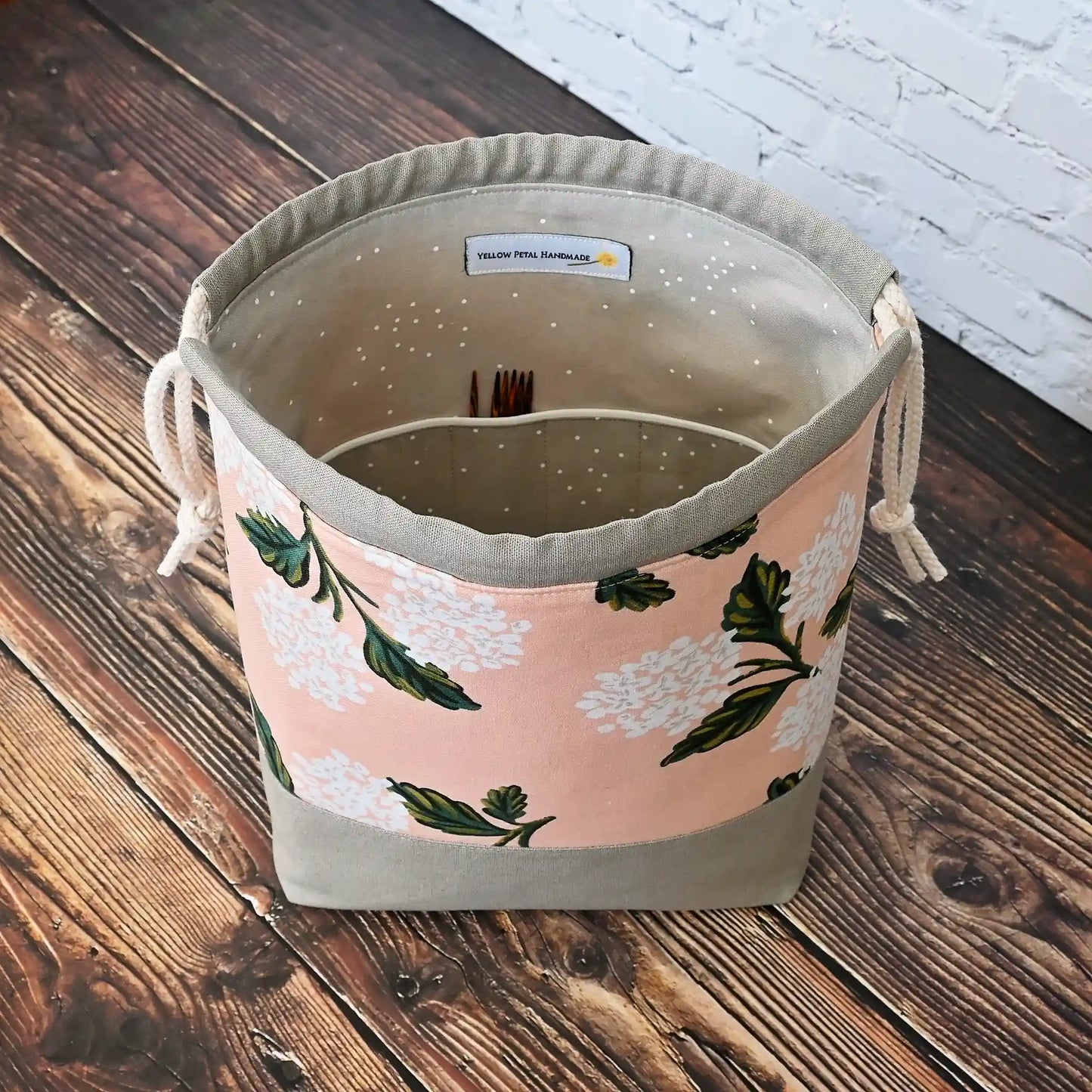 Pretty drawstring project bag made from a pretty peach hydrangea cotton from Rifle Paper Co and paired with a lovely putty coloured linen.  This bag has pockets inside and is lined in a putty coloured cotton with white spots.  Made in Canada by Yellow Petal Handmade.