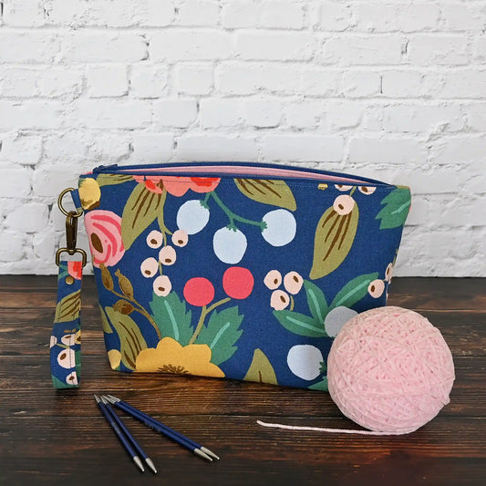 Blue floral canvas zippered pouch with removable wrist strap, lined in a pretty pink cotton.  Handmade in Canada by Yellow Petal Handmade.