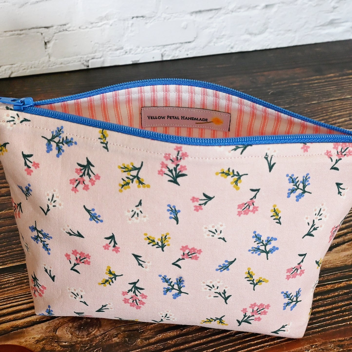 Pretty pink floral accessory pouch in Rifle Paper's Strawberry Fields collection.  Closes with a blue zip and lined in a pretty pink and cream striped cotton.