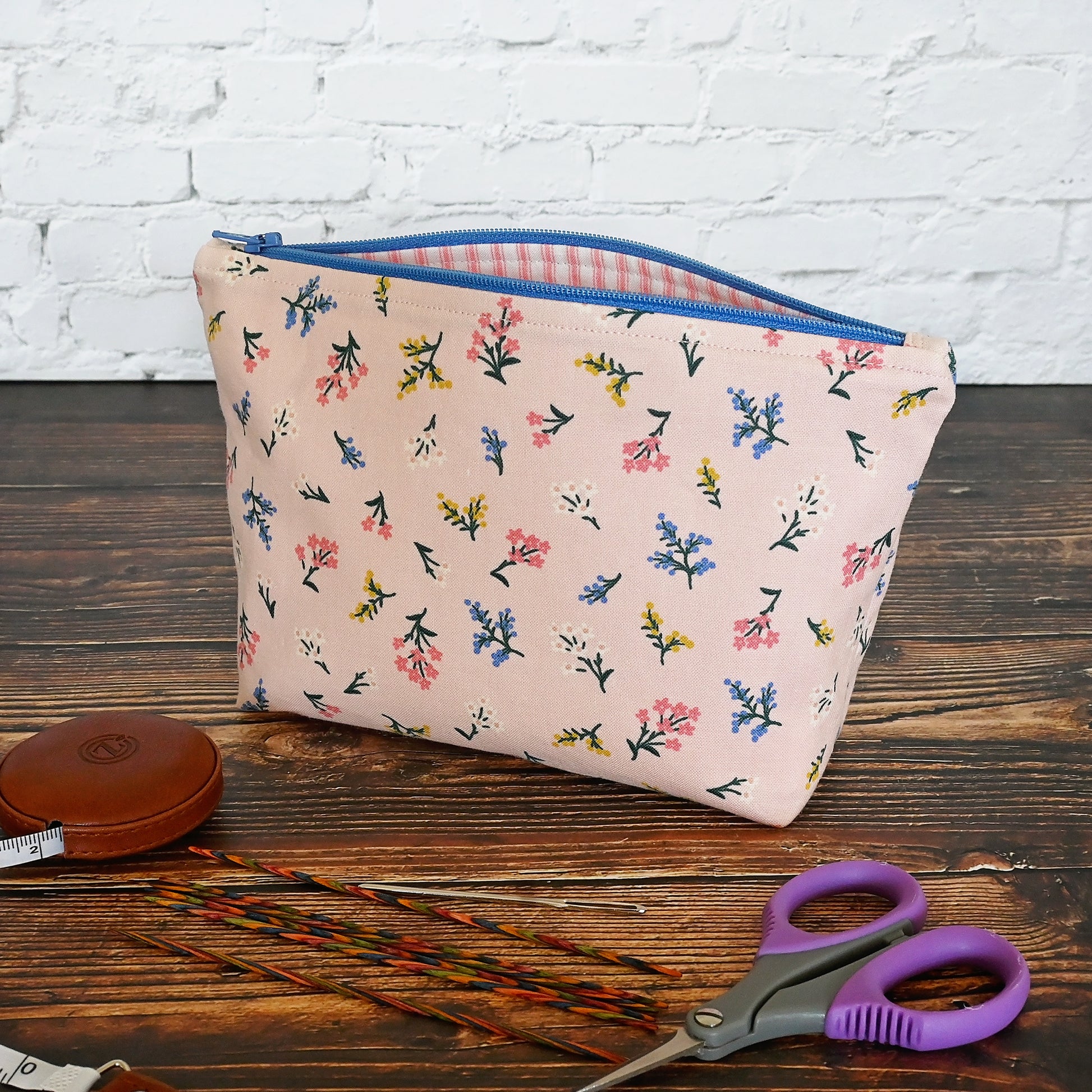 Pretty pink floral accessory pouch in Rifle Paper's Strawberry Fields collection.  Closes with a blue zip and lined in a pretty pink and cream striped cotton.