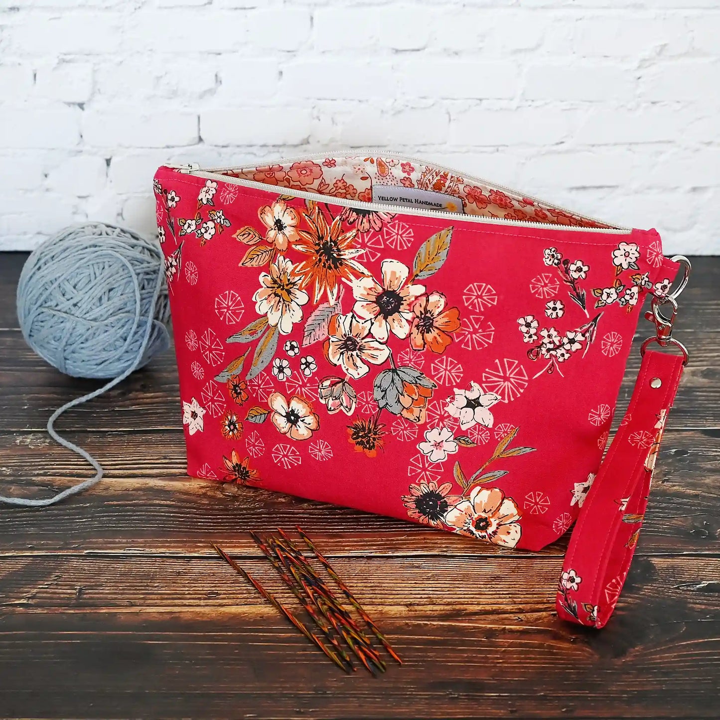 Red floral zippered pouch made from a gorgeous premium cotton from Art Gallery Fabrics.  Lined in a pretty cream and coral paisley floral and comes with a removable wrist strap.  Made in Canada by Yellow Petal Handmade.