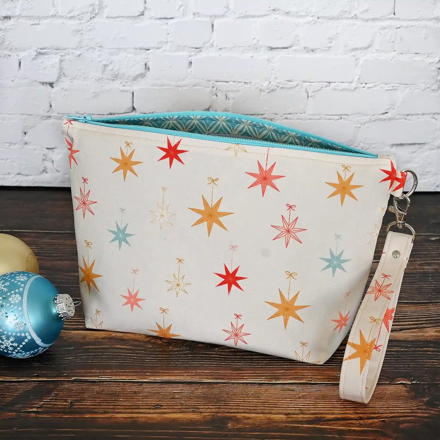 Pretty Pouch with Holiday Stars, lined in aqua fabrics.   Comes with a removable wrist Strap.  Made in Canada by Yellow Petal Handmade.
