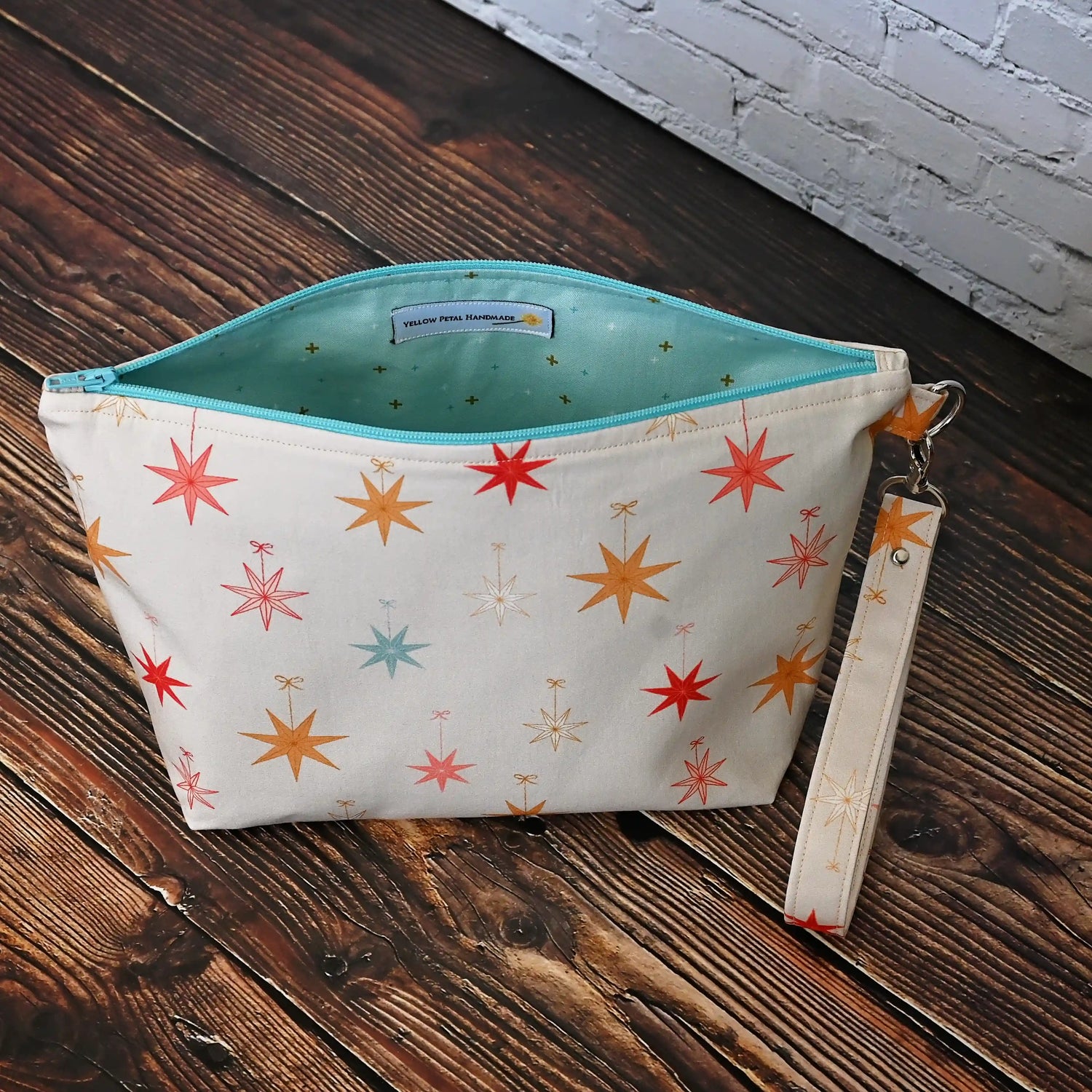 Pretty Pouch with Holiday Stars, lined in aqua fabrics.   Comes with a removable wrist Strap.  Made in Canada by Yellow Petal Handmade.