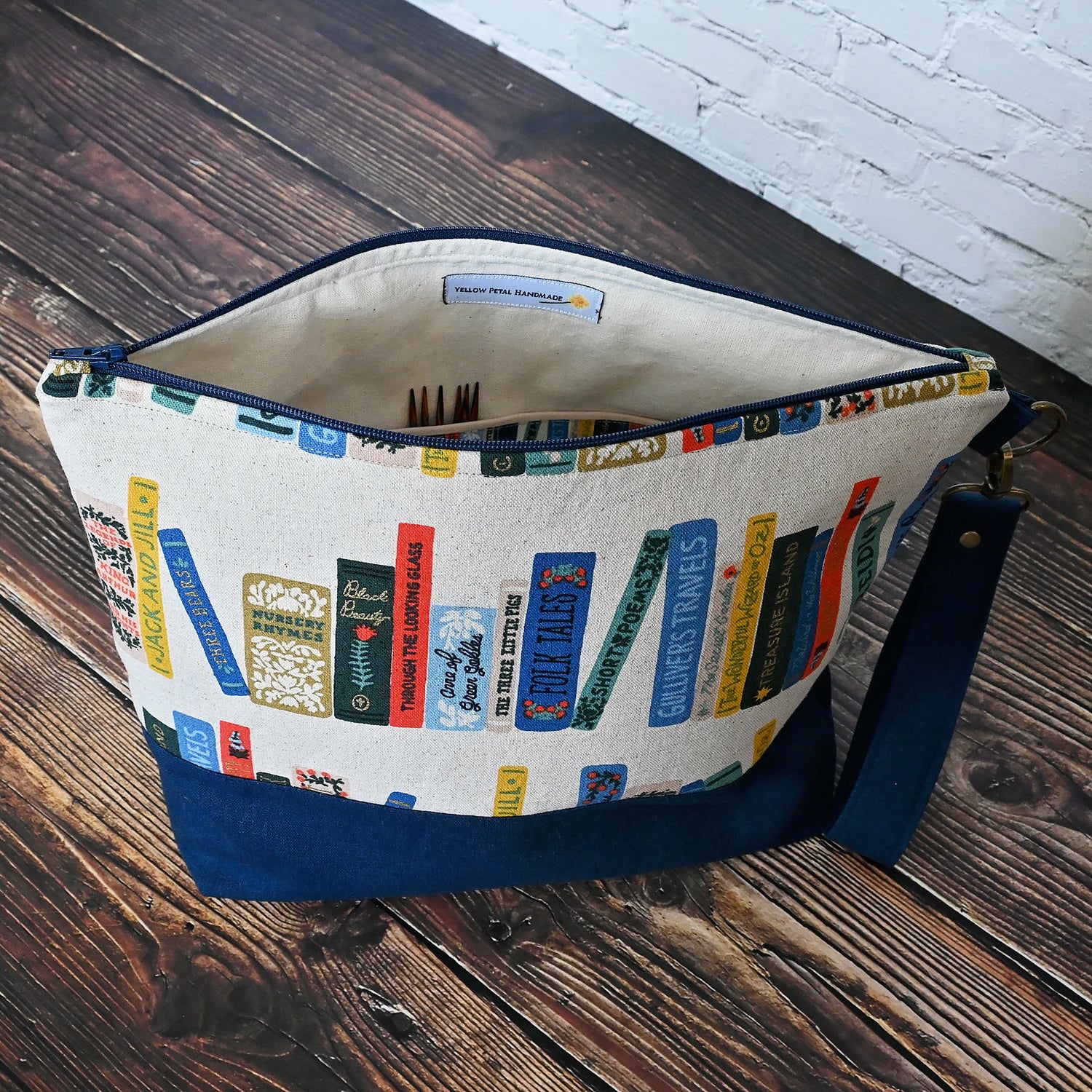 Fun project bag in Rifle Paper's Book Club Canvas.  Paried with a lovely navy linen and lined in an unbleached cotton with cotton Book Club Pockets.  Comes with a removable wrist strap.  Made in Canada by Yellow Petal Handmade.